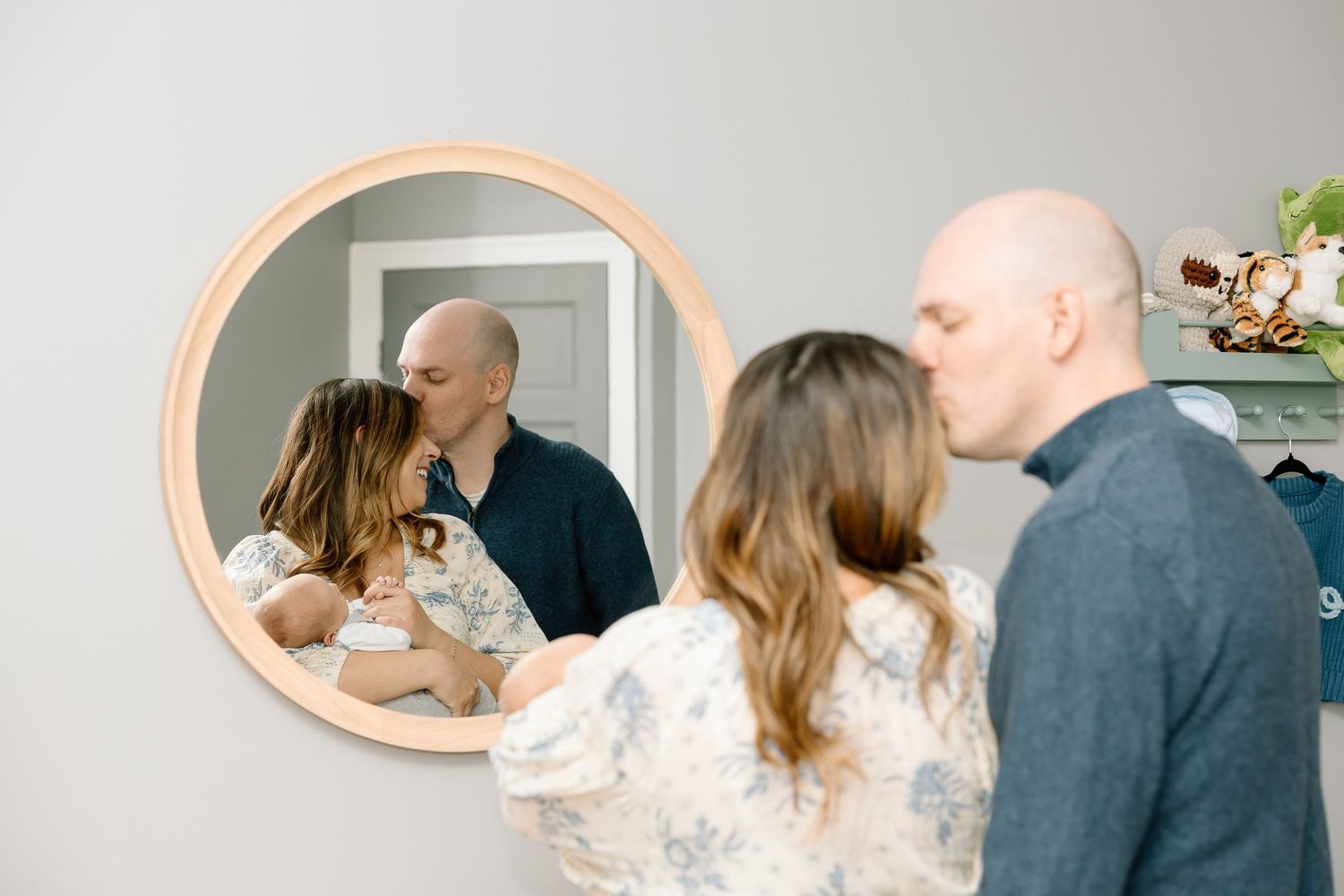 A romantic couple shares a tender kiss in a light-filled room during an intimate photo session.