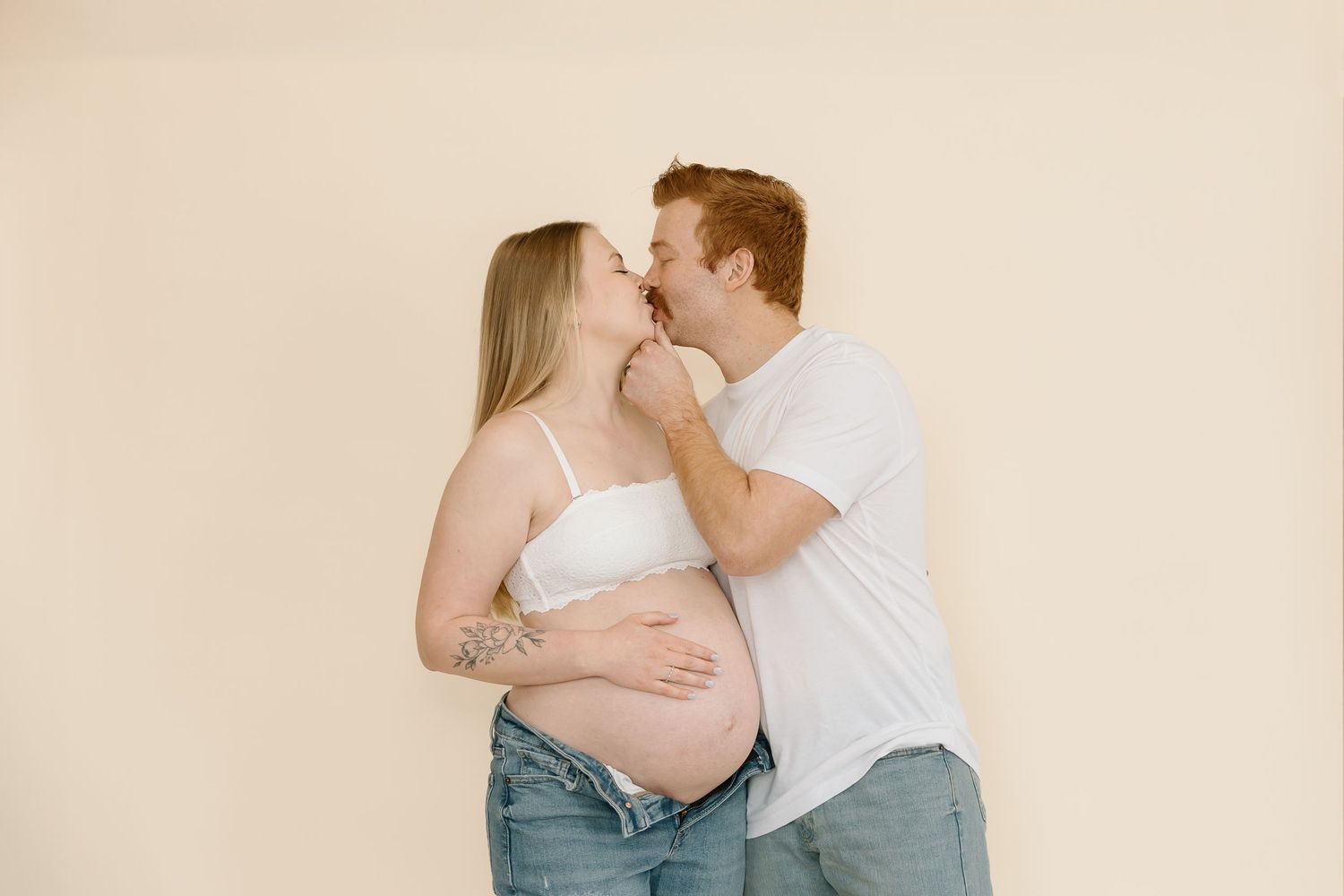 Tender maternity moment captured as couple embraces and shares intimate connection.