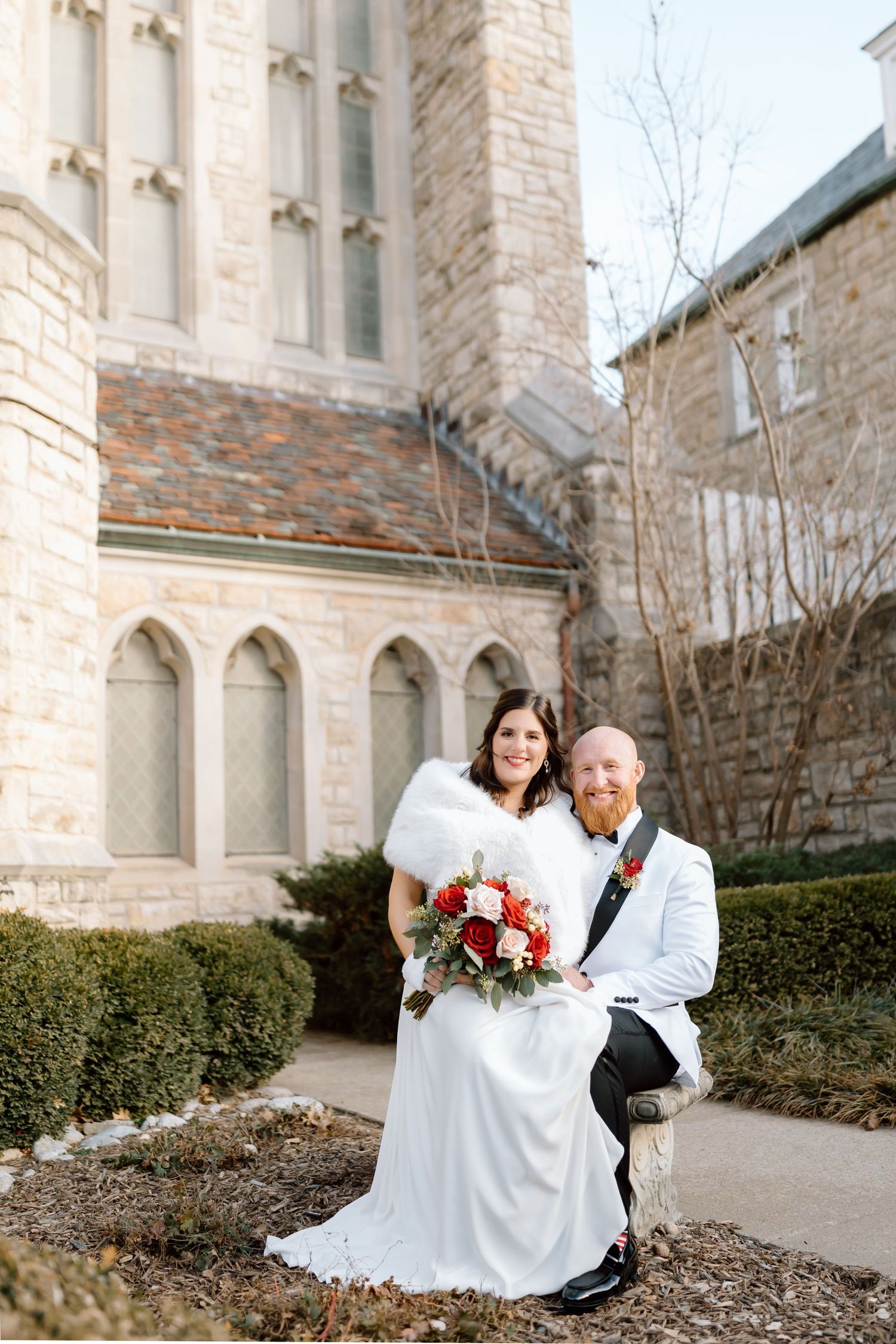 A romantic wedding photo session outside a stone church building with elegant architectural details.