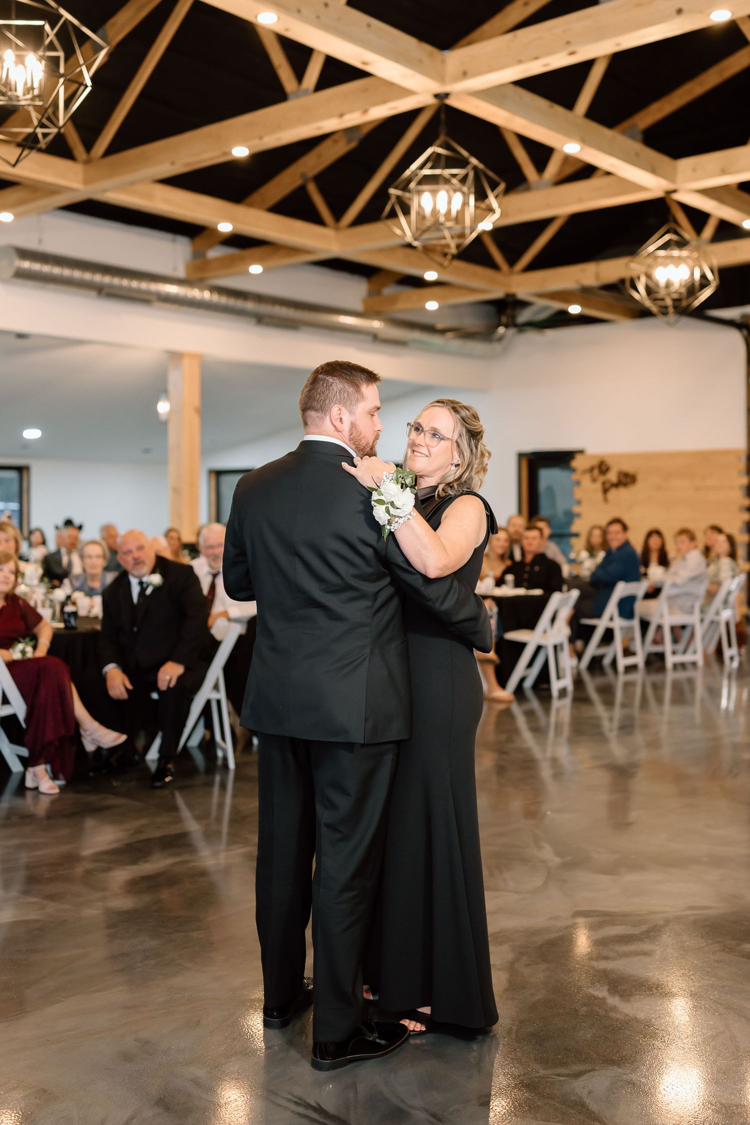 A sequence of dance moments at a wedding reception showing couples swaying on a polished concrete floor under rustic lighting.
