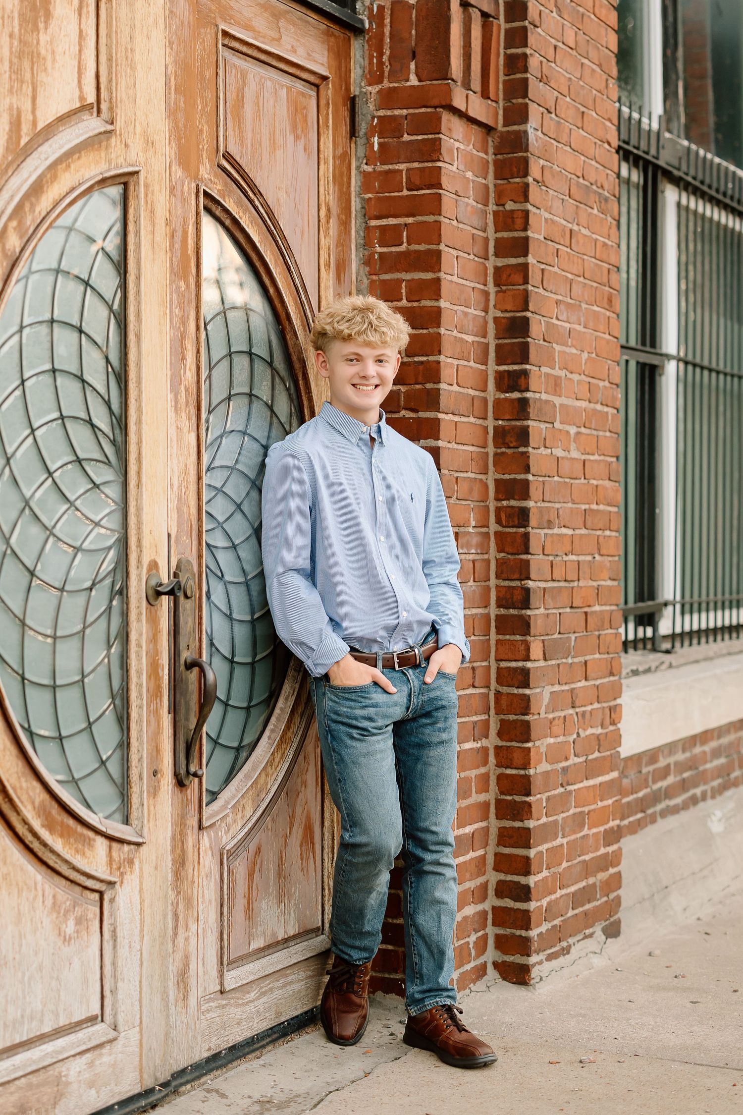 Three connected photos show a child posing against a brick wall with round decorative windows in a casual outdoor setting.