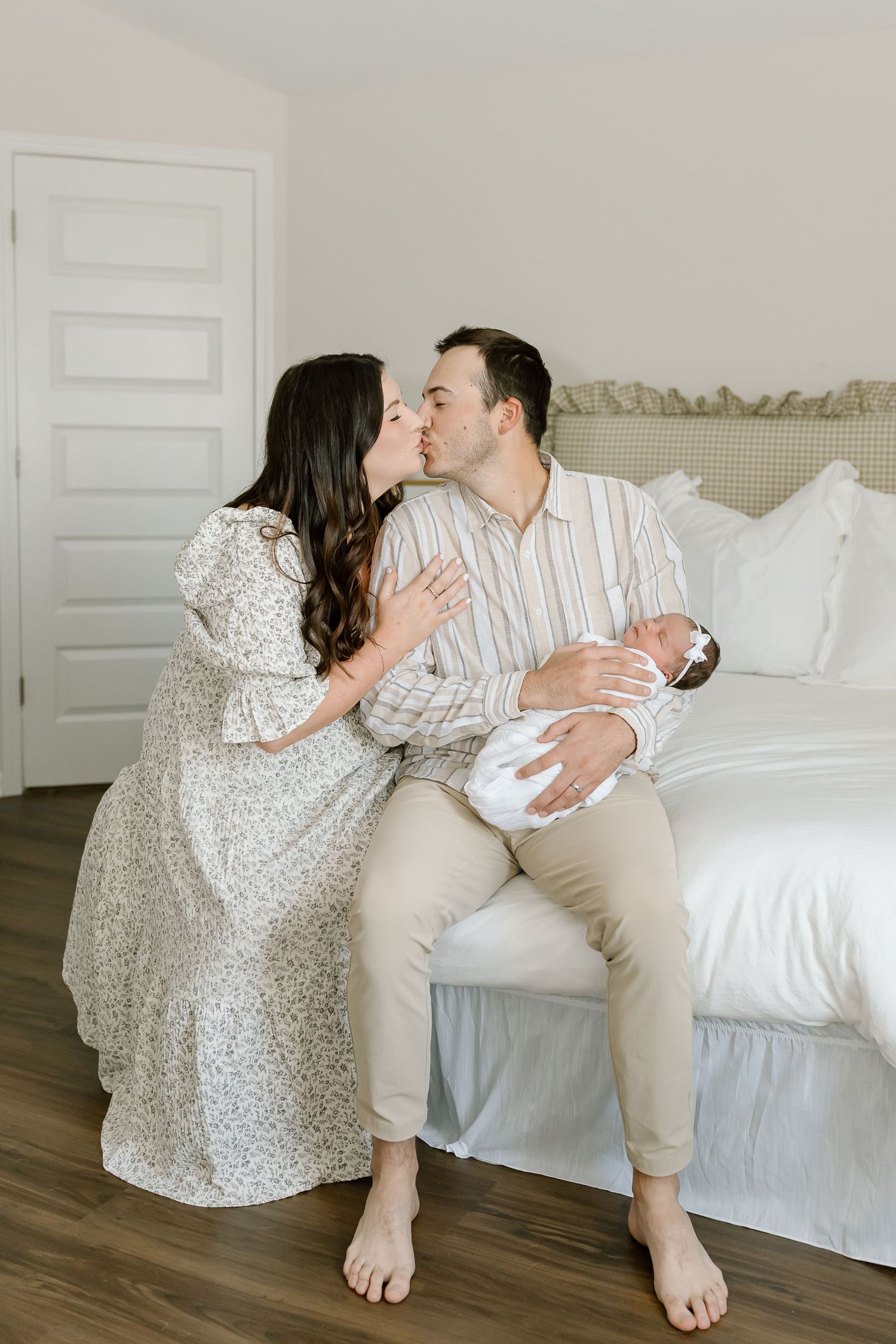 A couple shares intimate moments on a white bed while wearing coordinating white and beige outfits in a romantic photo series.