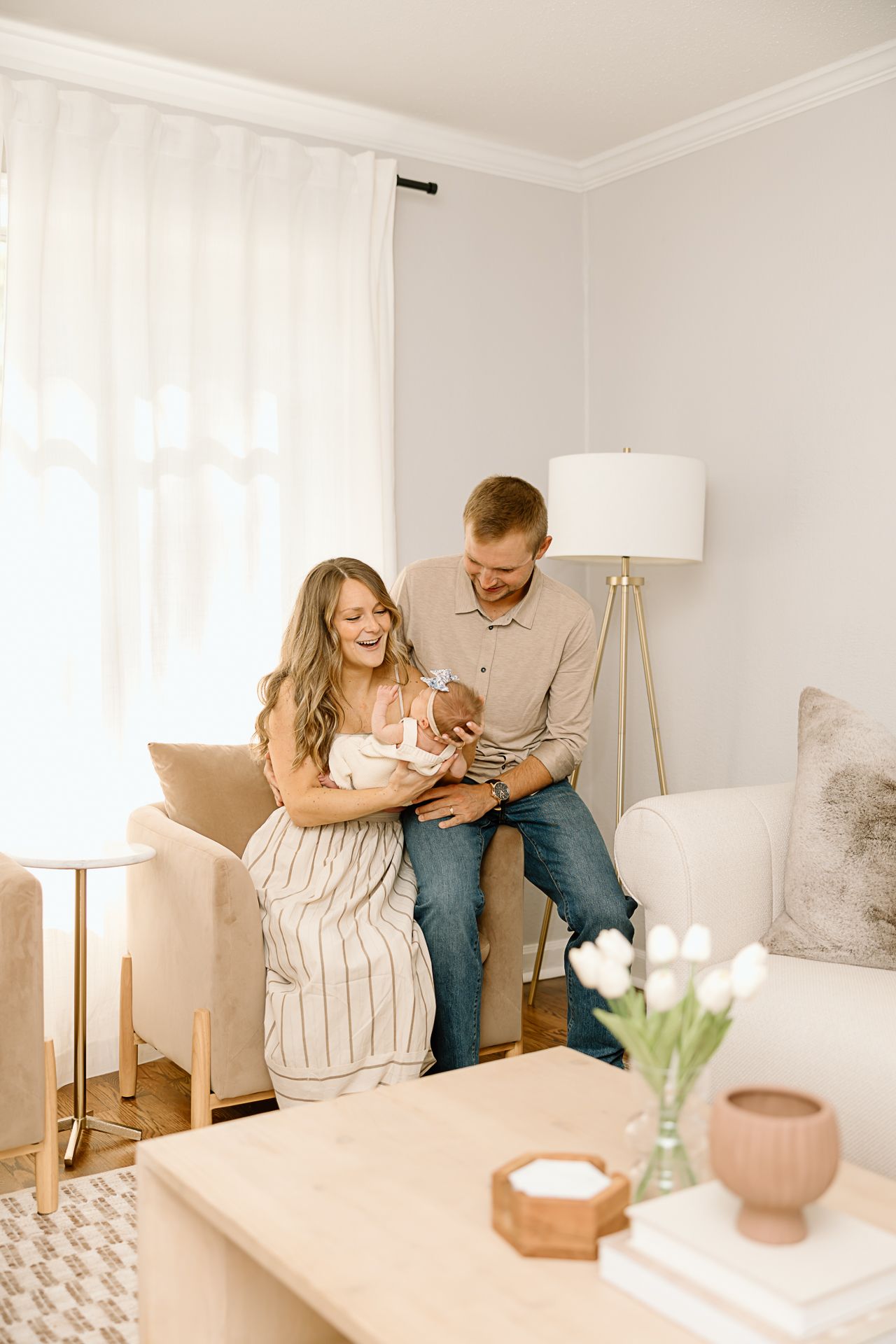 Candid family moment in bright living room with modern decor and white curtains.