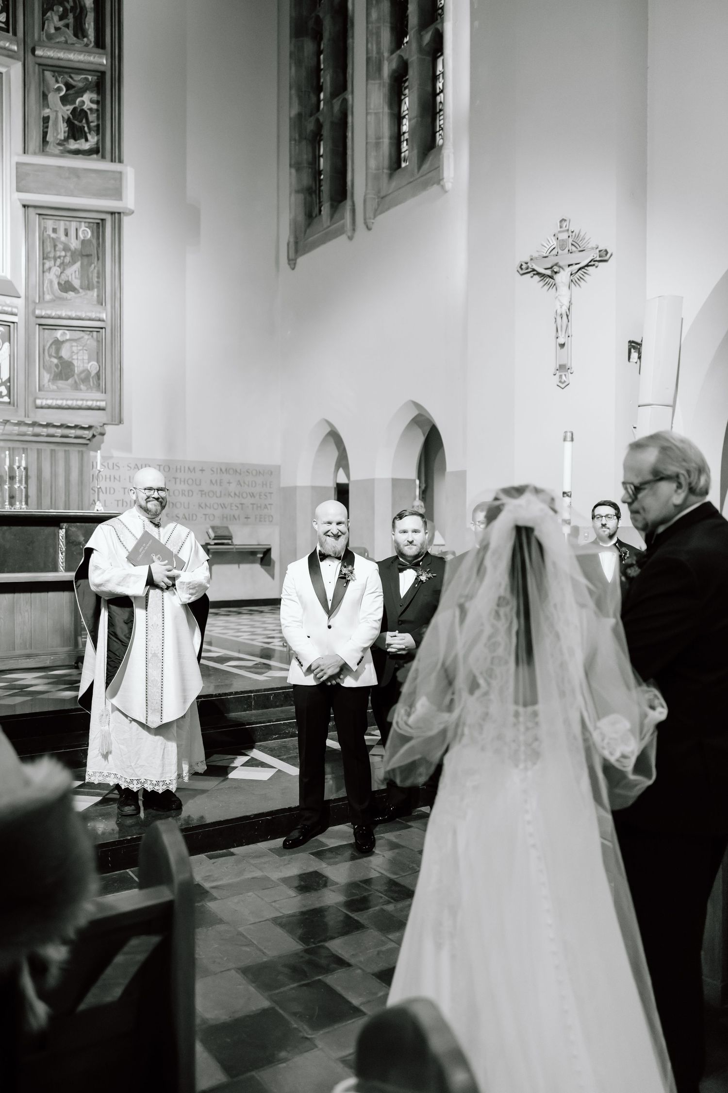A series of black and white wedding ceremony photos showing moments between clergy and a bride in a traditional church setting.