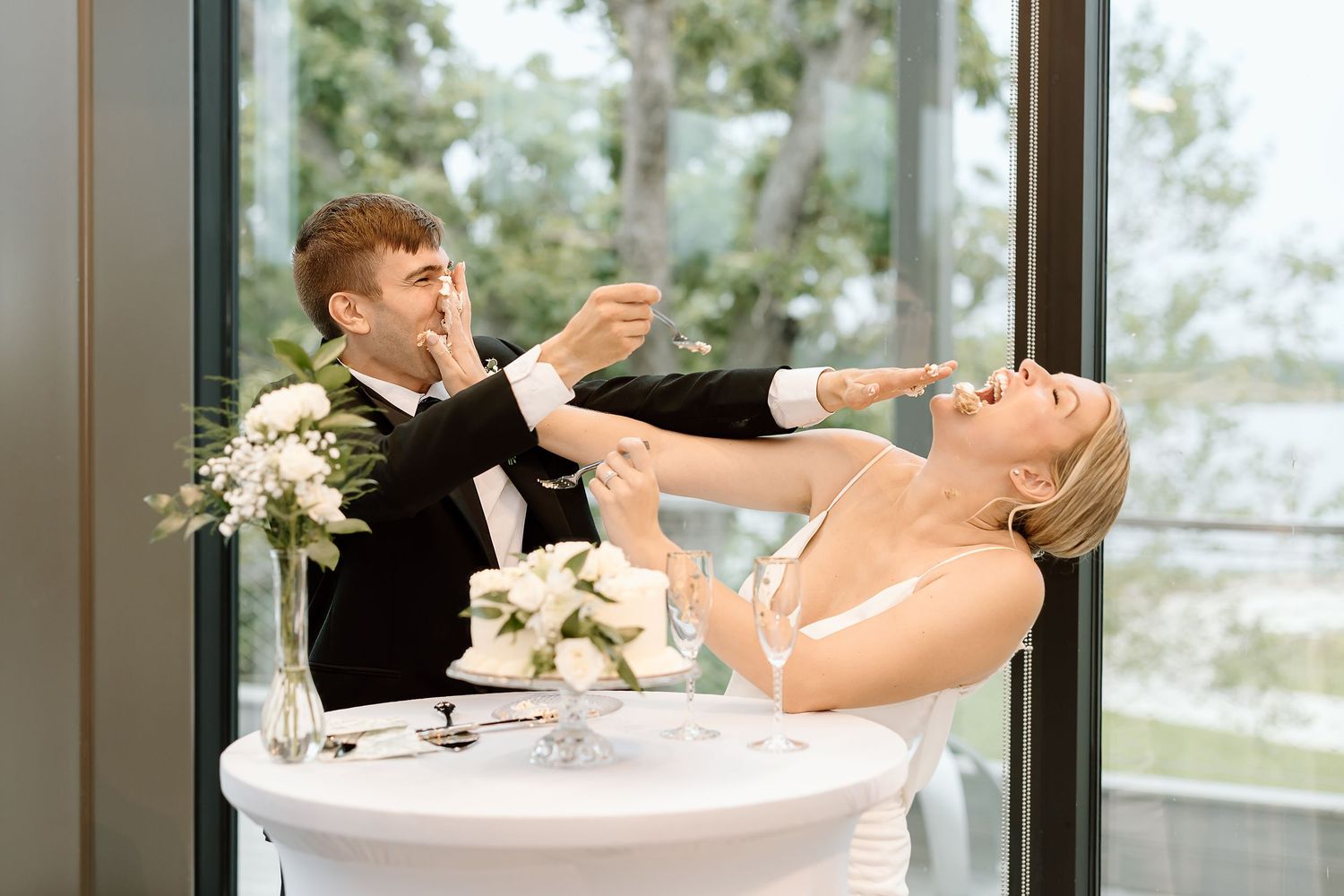 Five sequential wedding photos show a couple sharing laughter while feeding each other wedding cake during their reception.