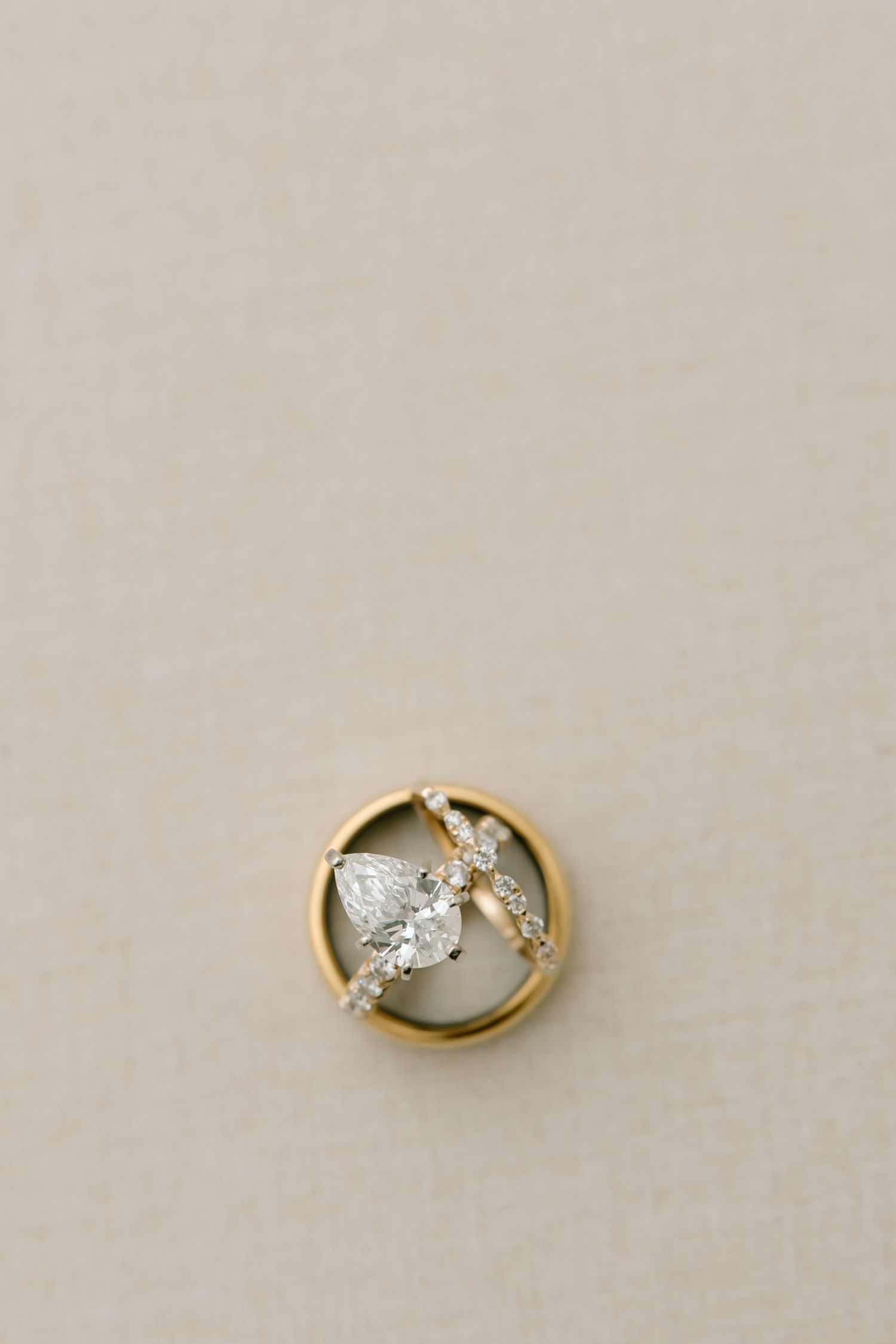 A gold ring with a white marquise-shaped diamond center stone and small accent diamonds in an elegant setting.