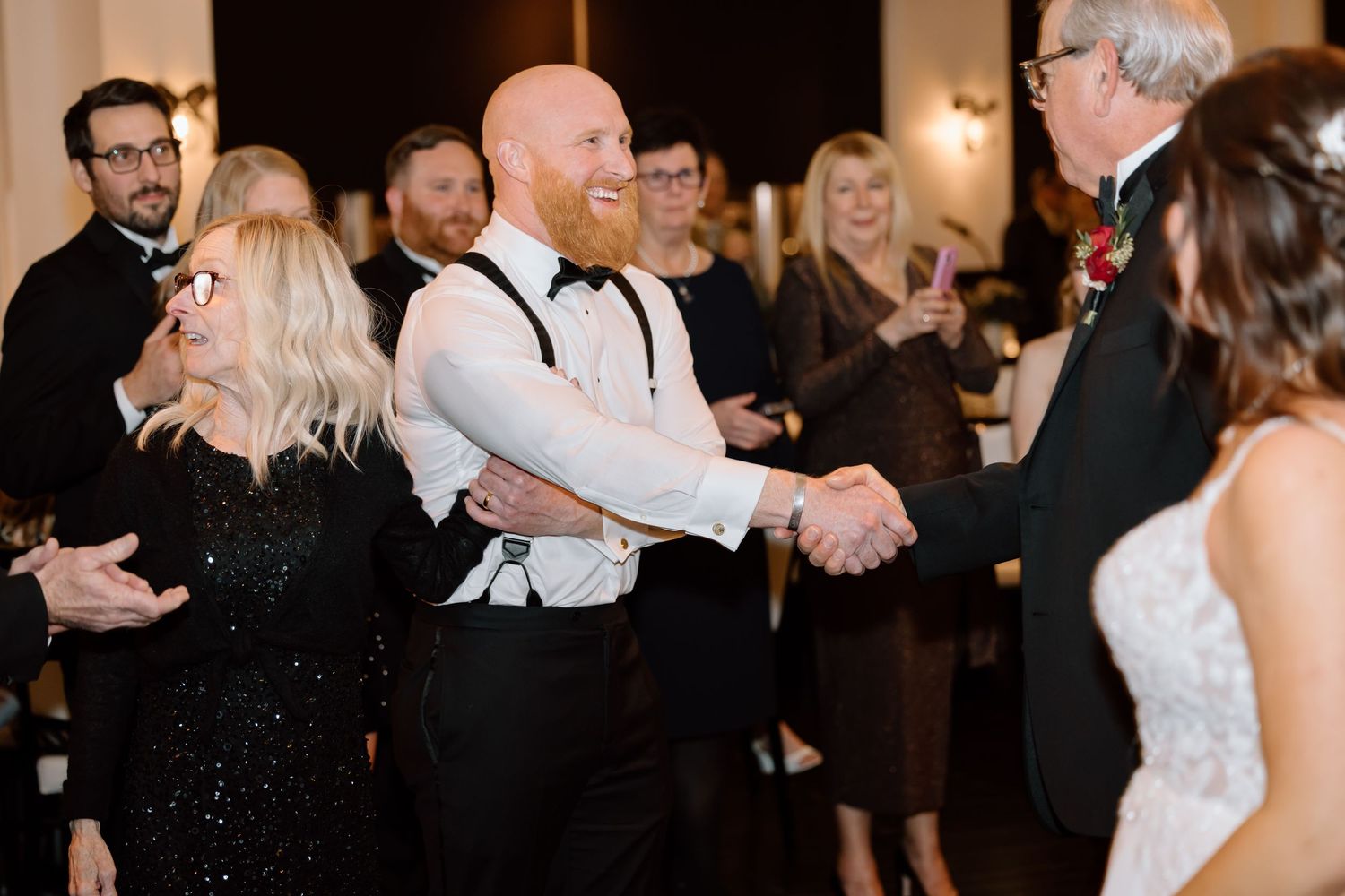 Couples dancing together on a dimly lit dance floor at an elegant evening celebration.