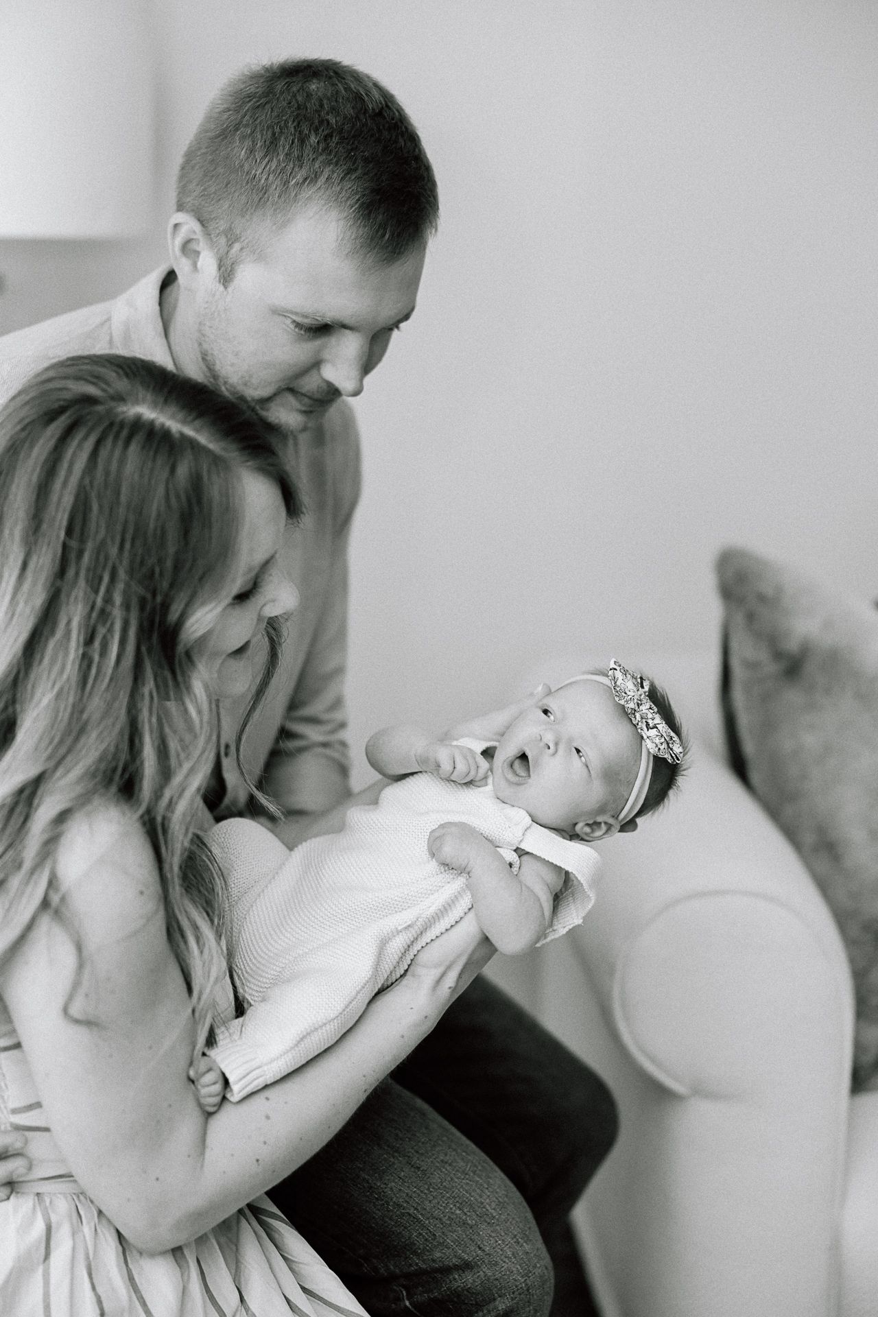 Black and white intimate family portrait in soft natural window light.
