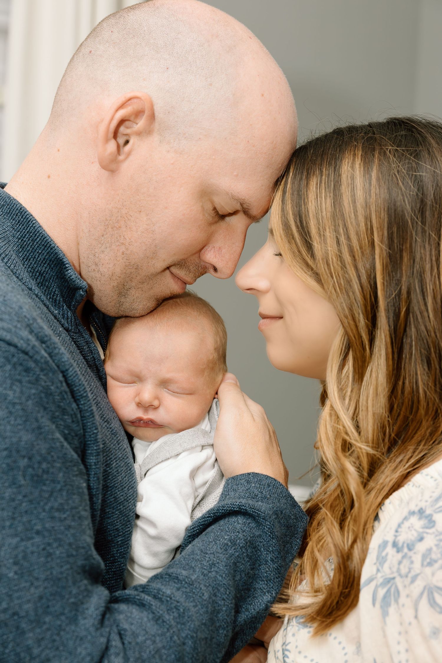 A tender family moment captured in a series of intimate portraits showing parents with their newborn baby.