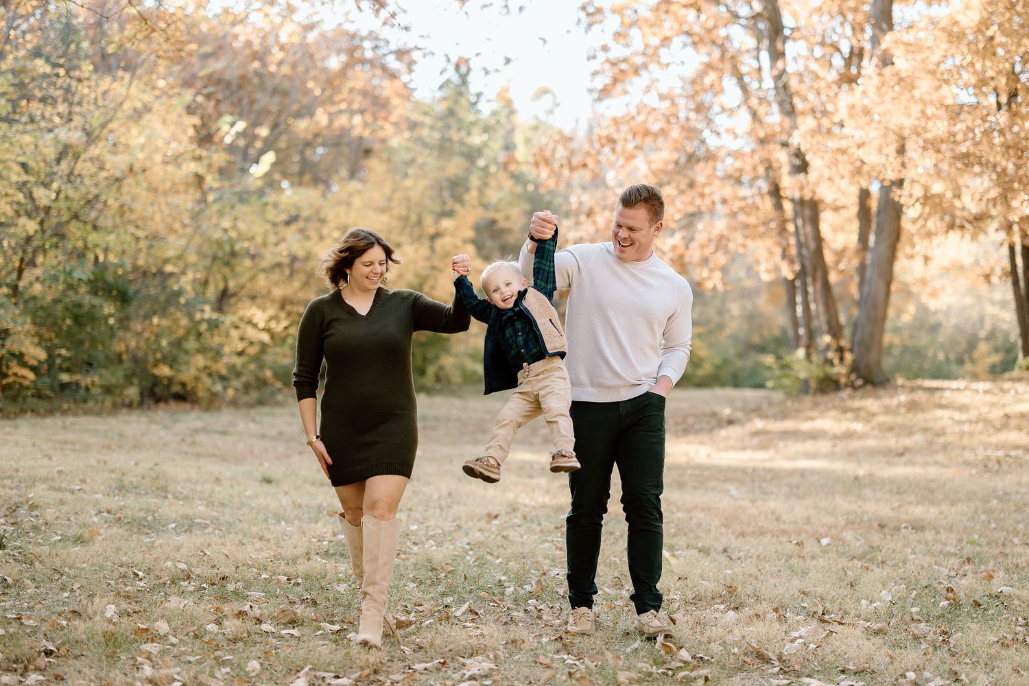 Family enjoying playful moment together in autumn park setting.
