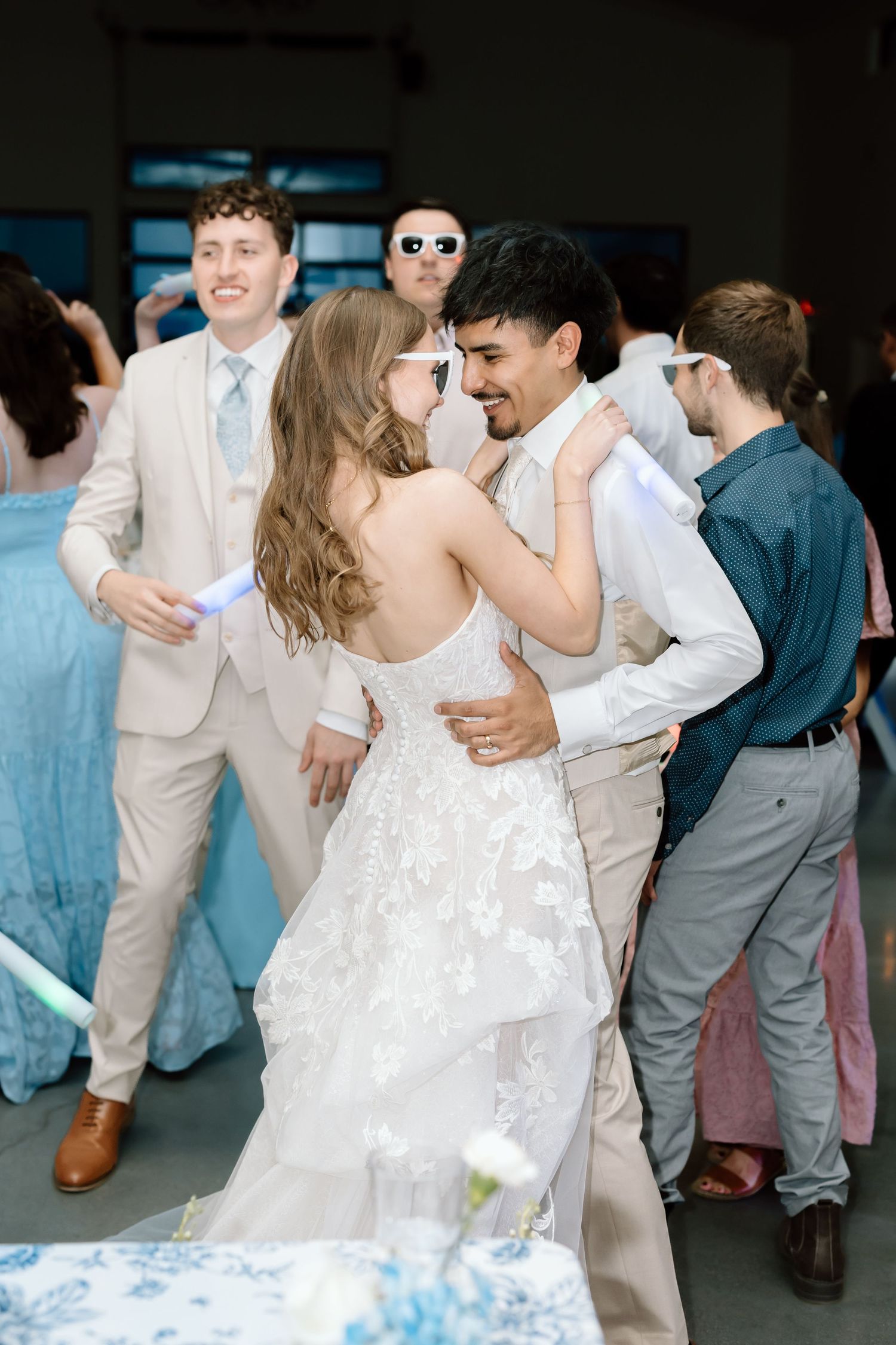 Bride and groom share a romantic dance surrounded by guests at their wedding reception.