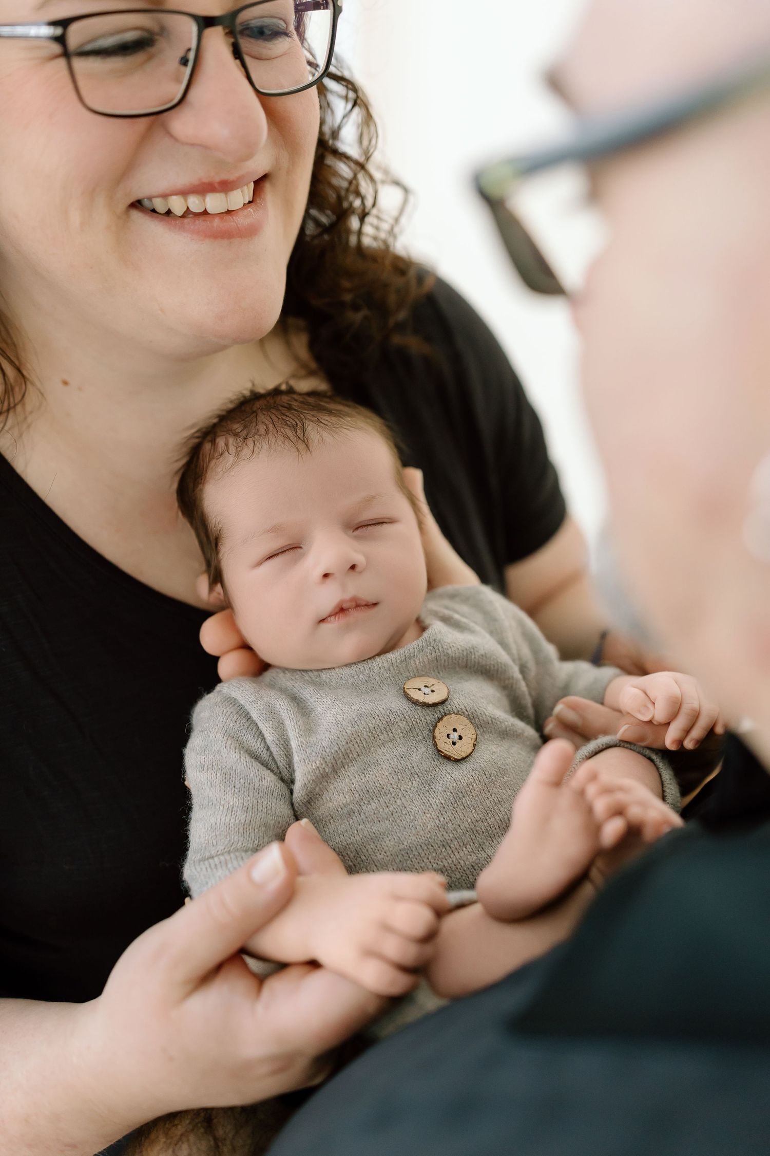 A series of intimate family portraits showing tender moments between parent and infant in soft, natural lighting.
