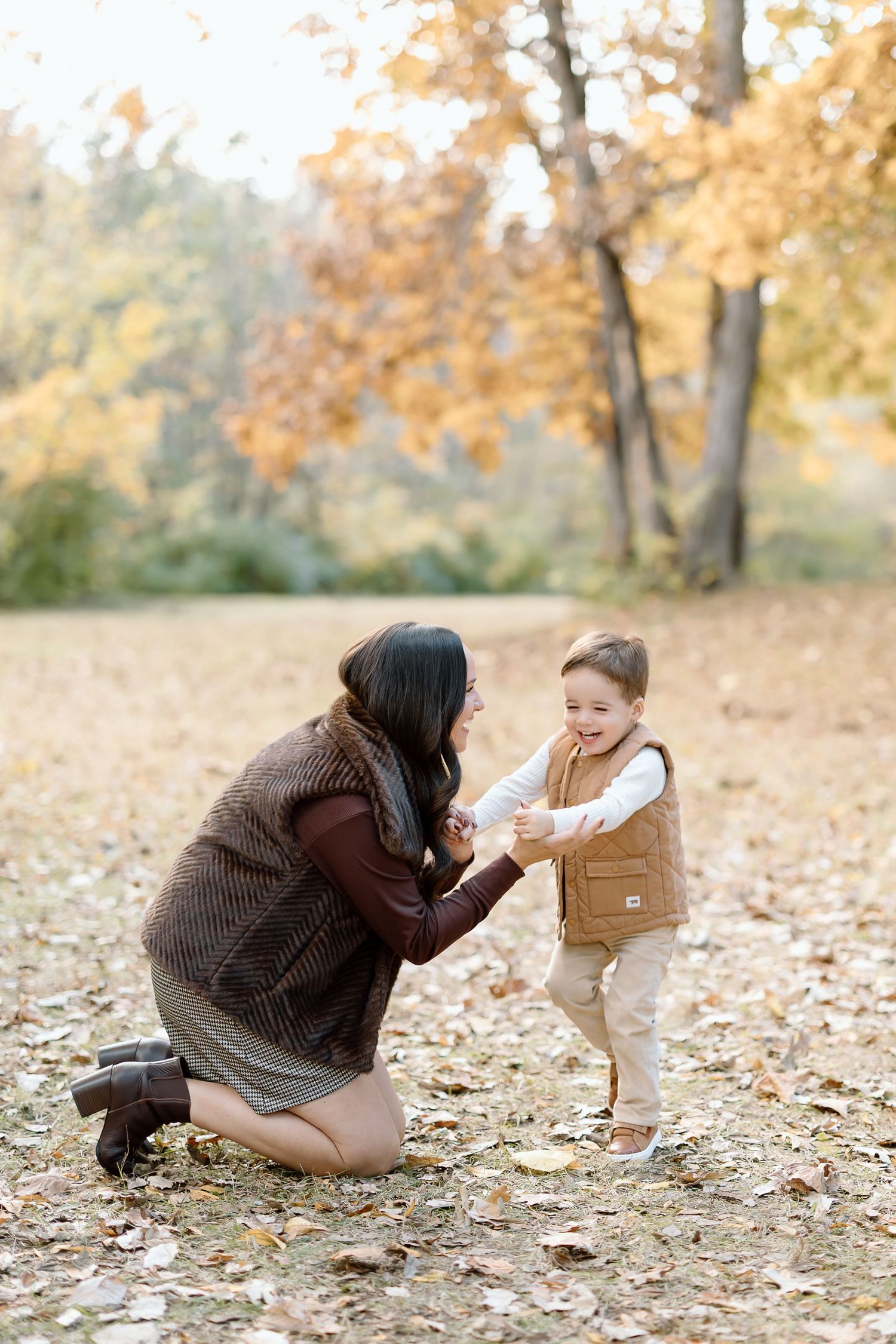 A sequence of photos showing a photographer and child interacting playfully among fallen autumn leaves in a park.