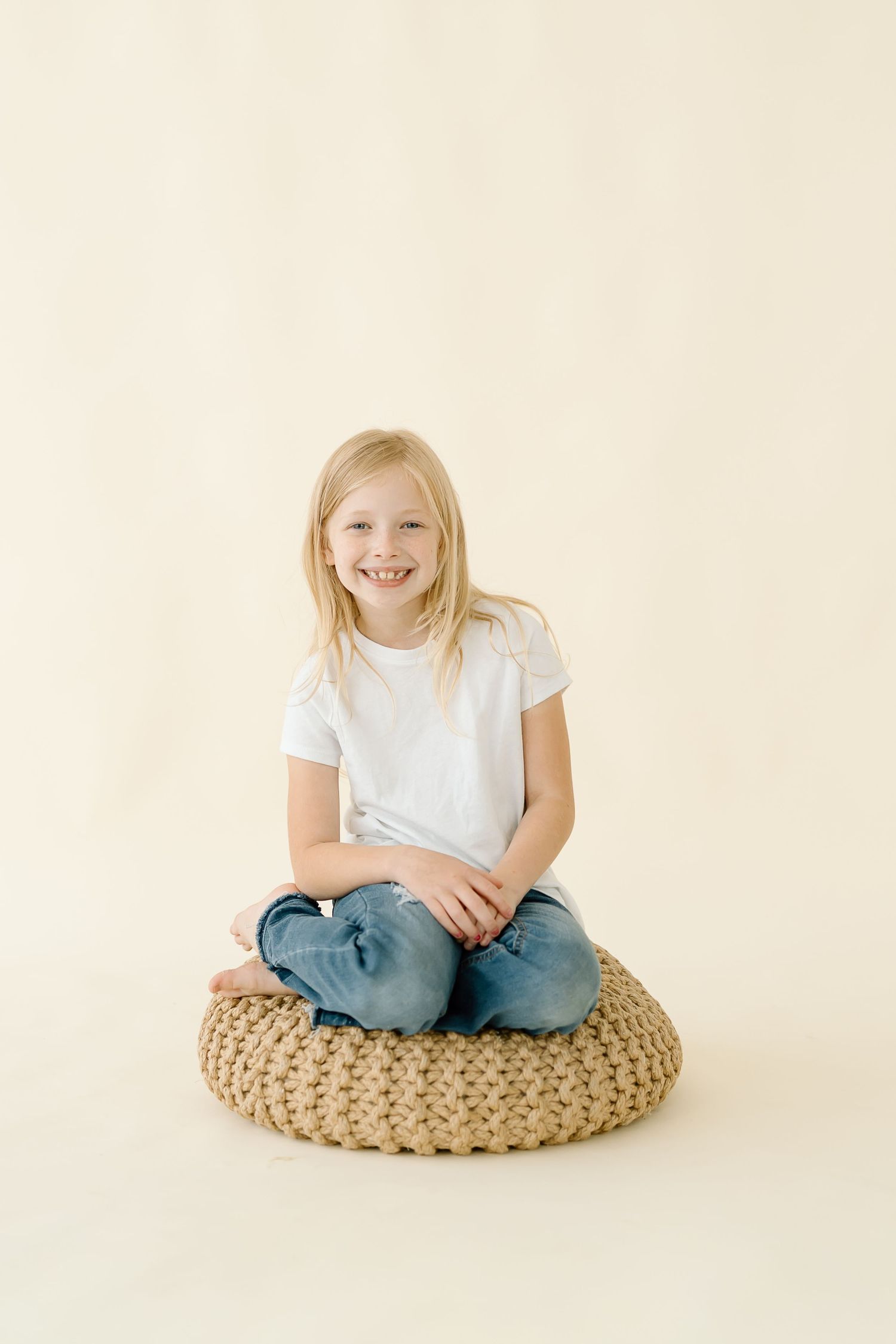 Three sequential photos show a child sitting cross-legged on a round woven floor cushion against a white background.