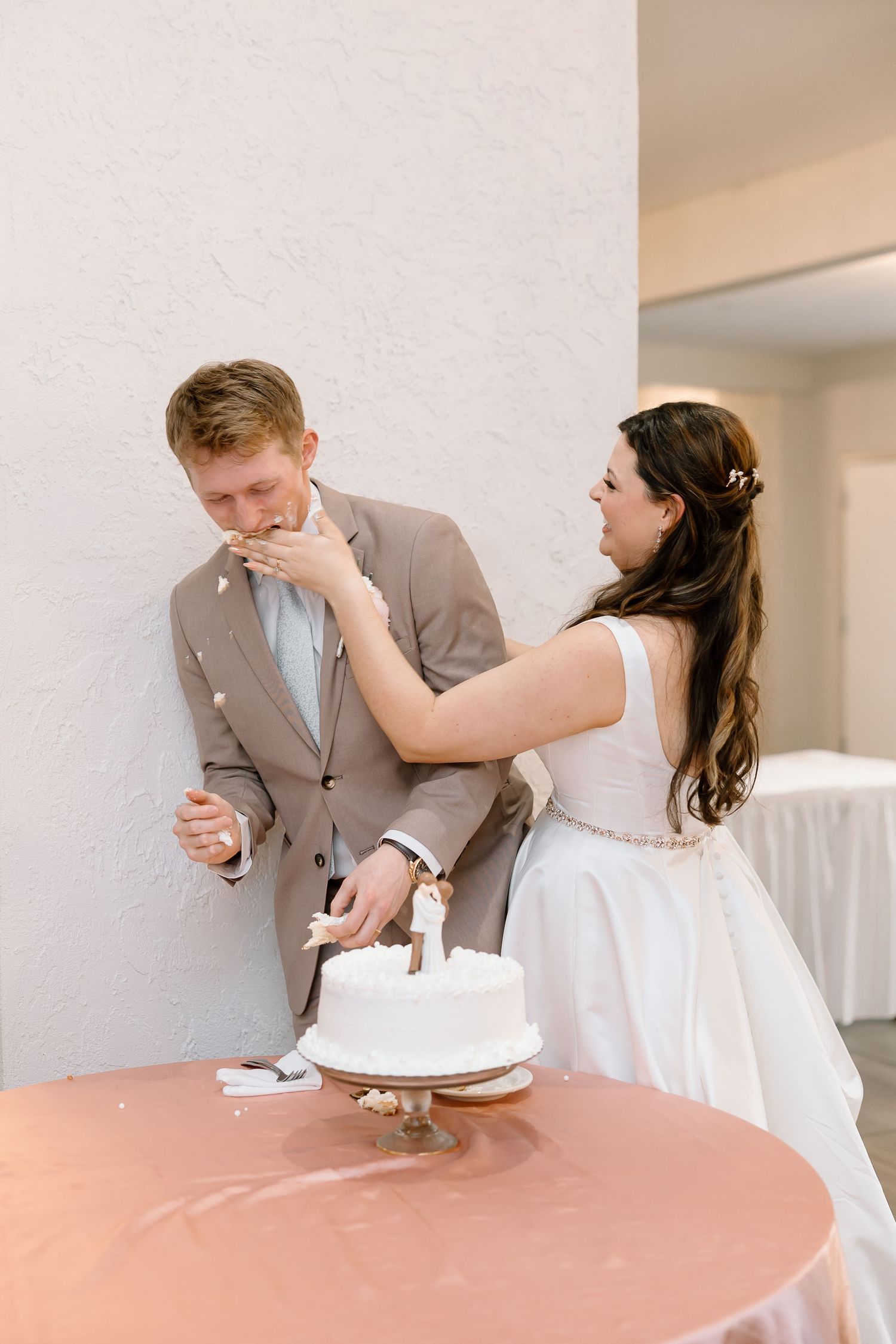 A couple shares an emotional first look moment before their wedding ceremony at an indoor venue.
