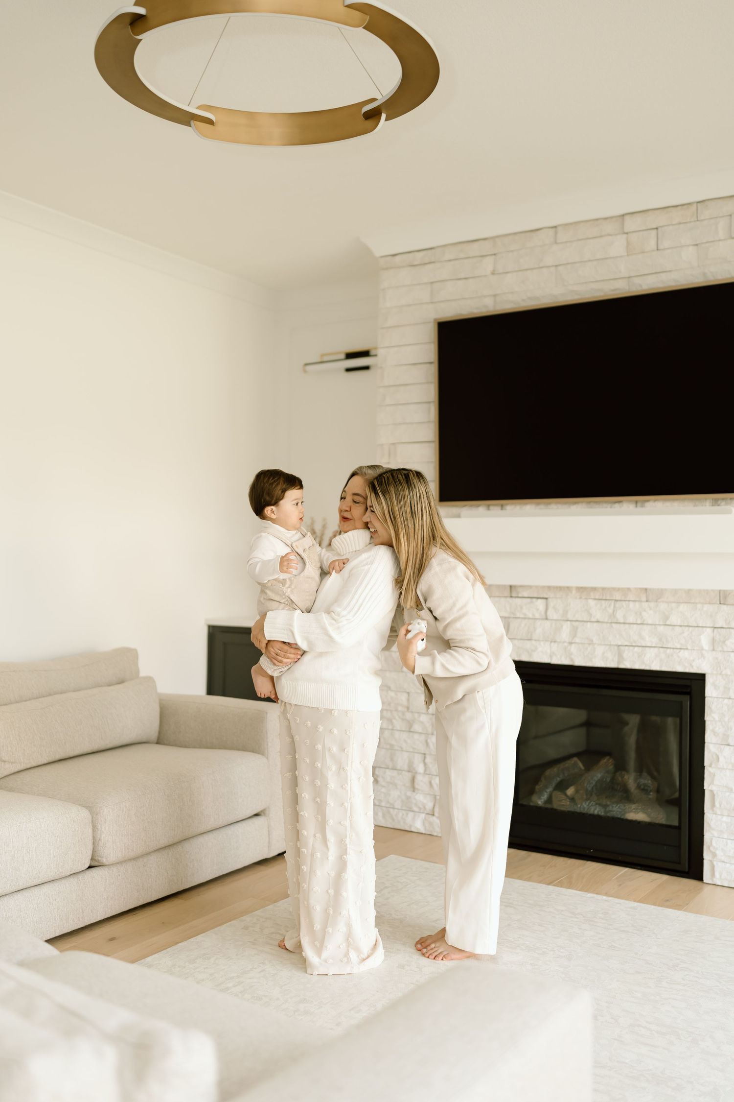 A series of four photos showing people in white outfits sitting and standing in a modern minimalist living room.