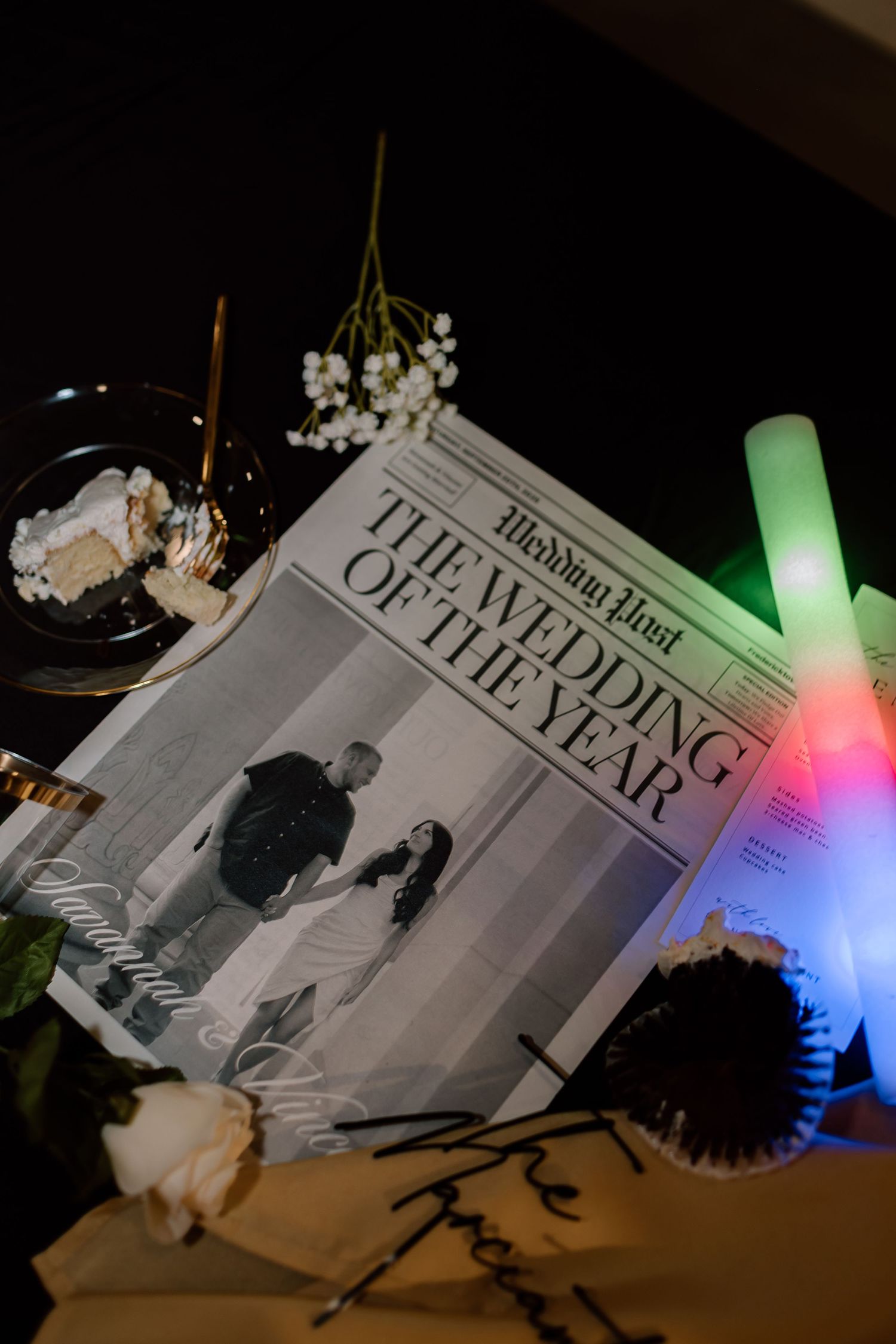A series of black and white photographs in a book illuminated by colorful LED lights creating a dramatic lighting effect.