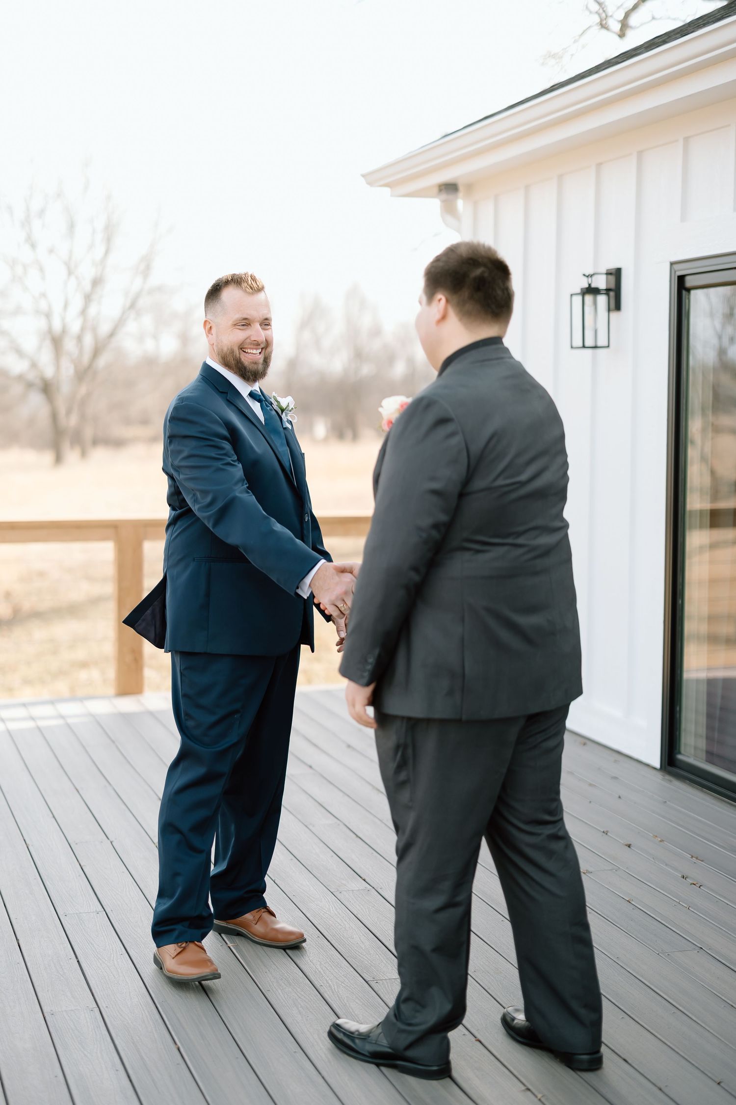 Two people in suits stand on a white wooden deck having an animated conversation in a series of candid shots.