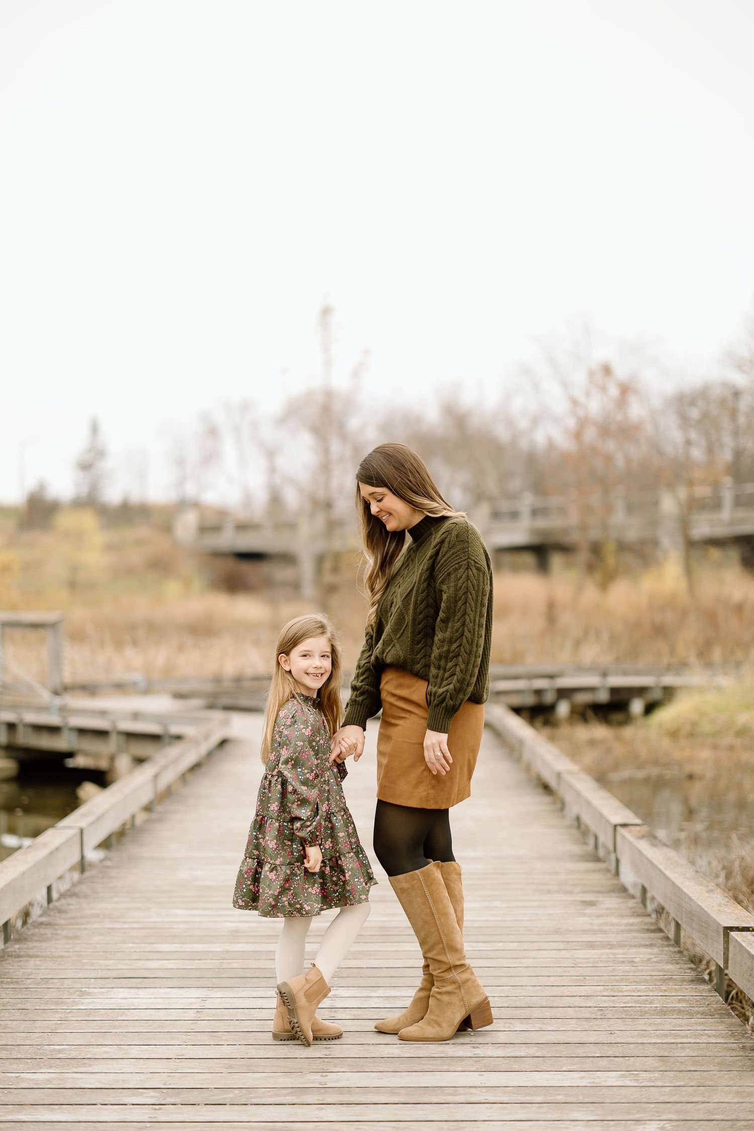 Sweet autumn photoshoot on a rustic wooden boardwalk showing coordinated fall fashion outfits.