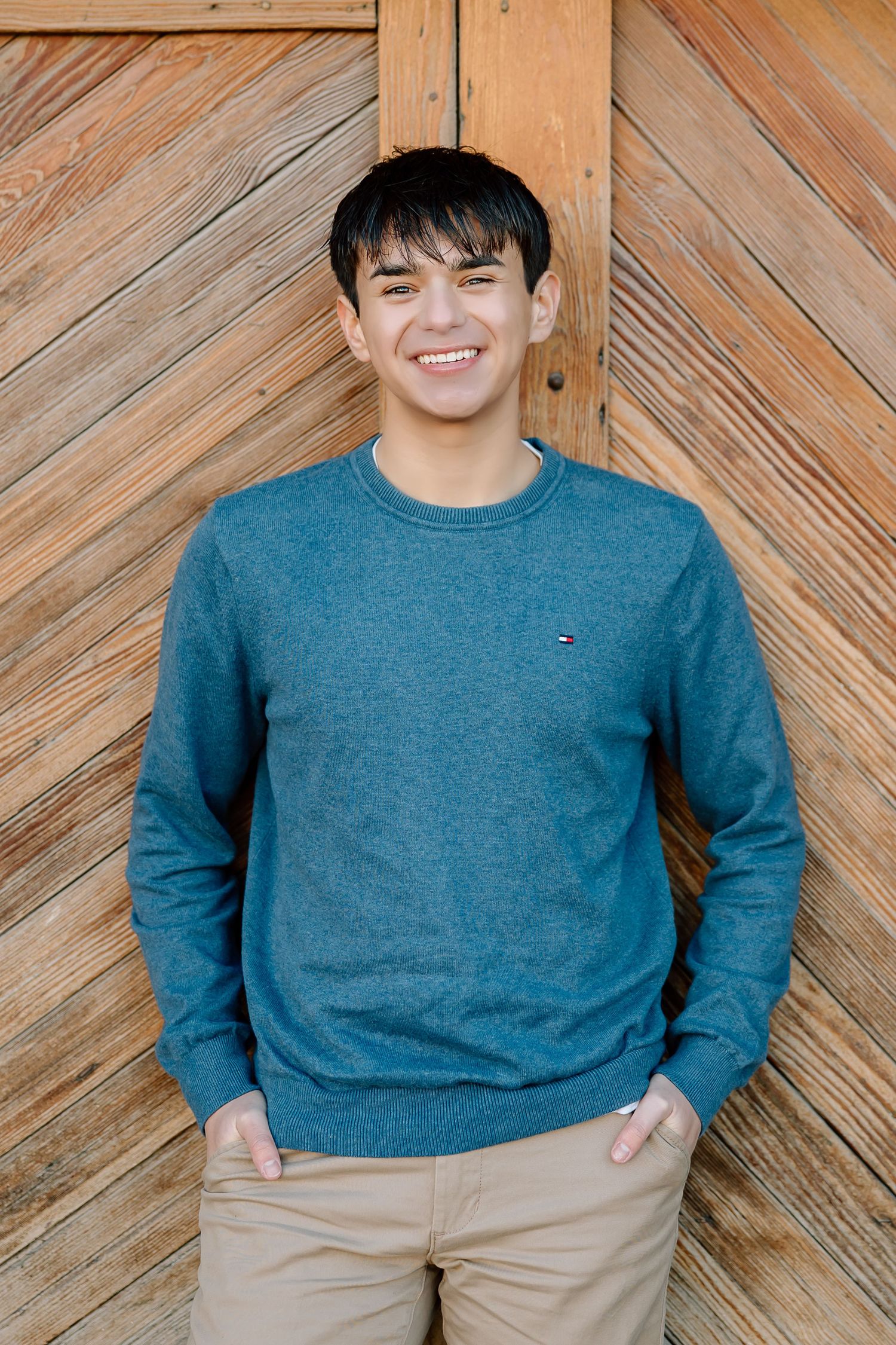 Casual portrait against wooden diagonal pattern backdrop.