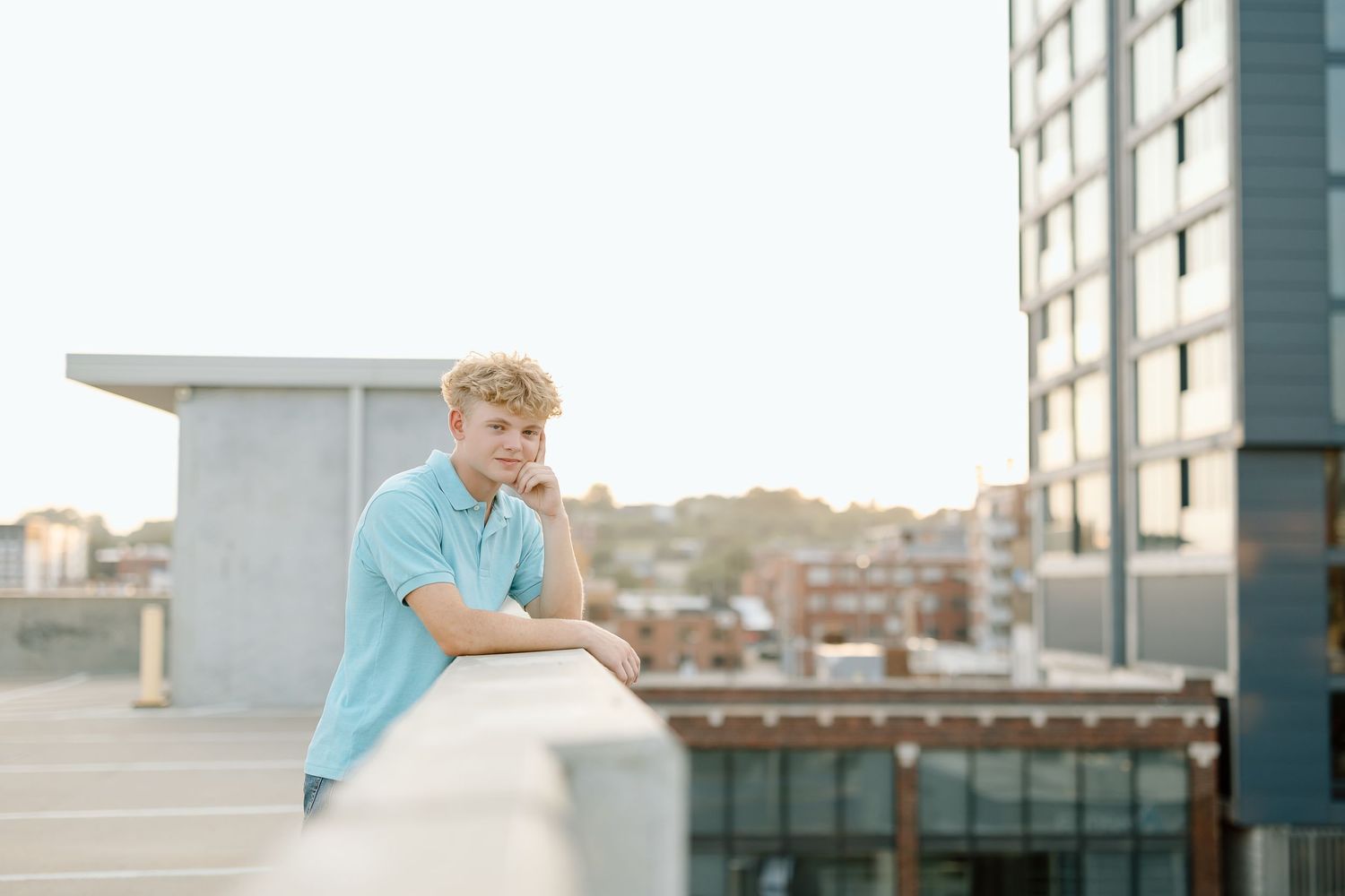 A series of four photos showing a person in a teal shirt standing against a city backdrop on a rooftop.