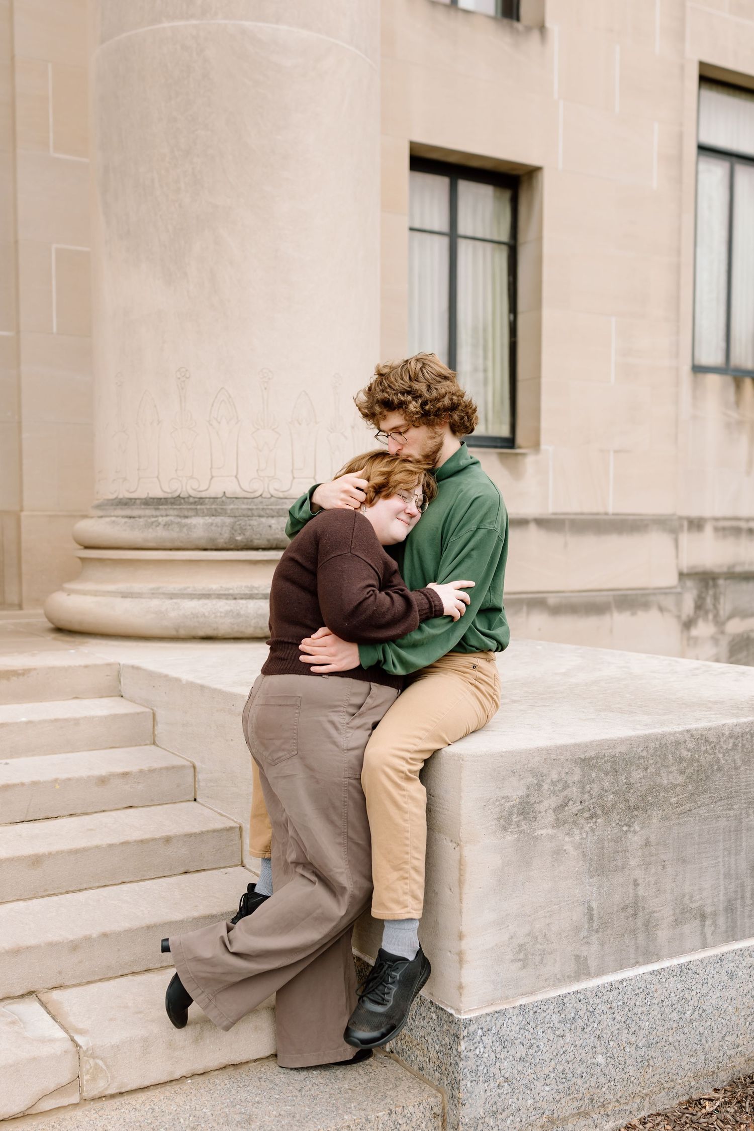 A series of four images showing two people in an intimate embrace sitting on concrete steps outside a building.