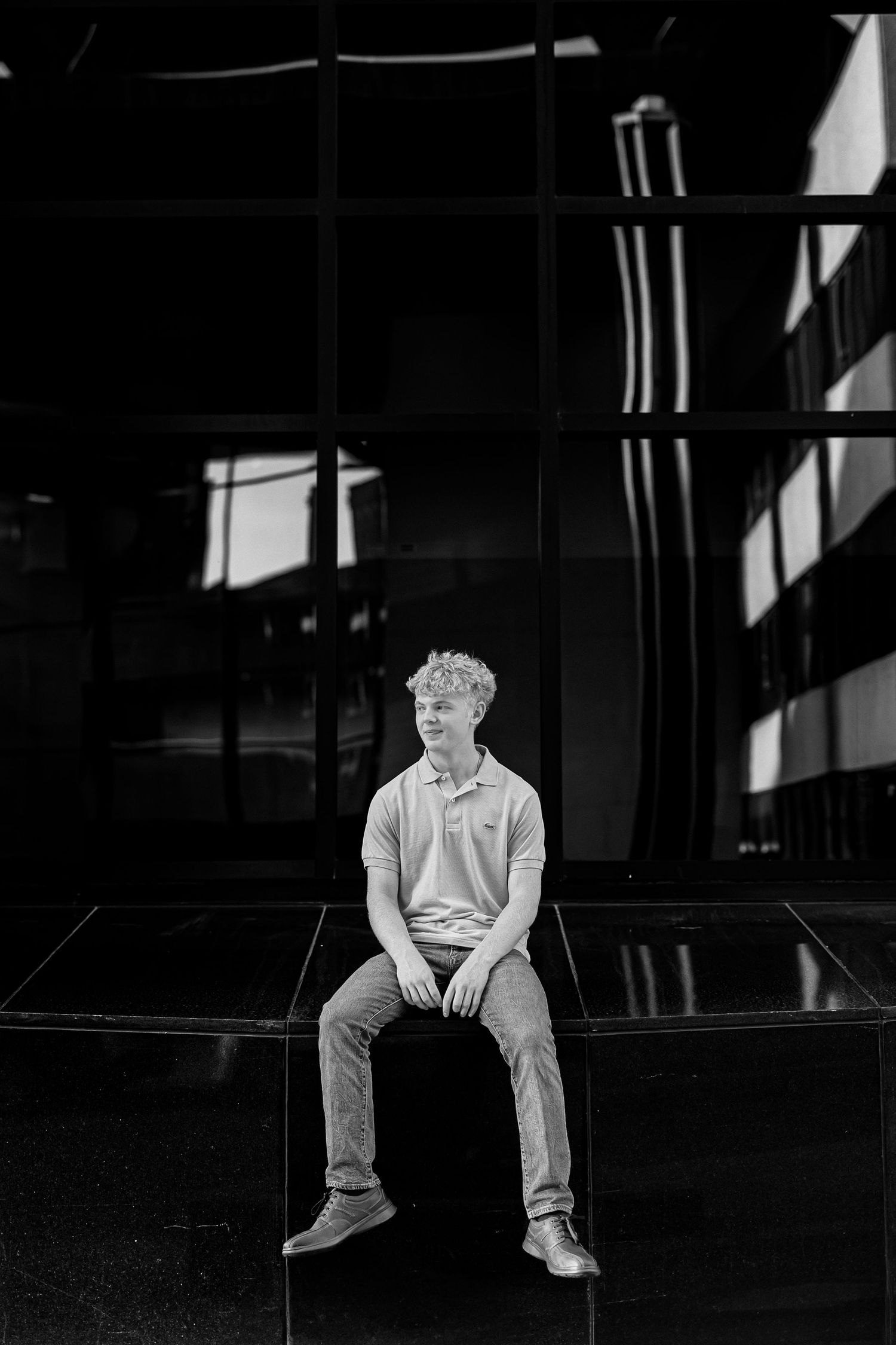 A black and white photo series shows a person sitting alone in dark spaces, creating a moody atmospheric sequence.