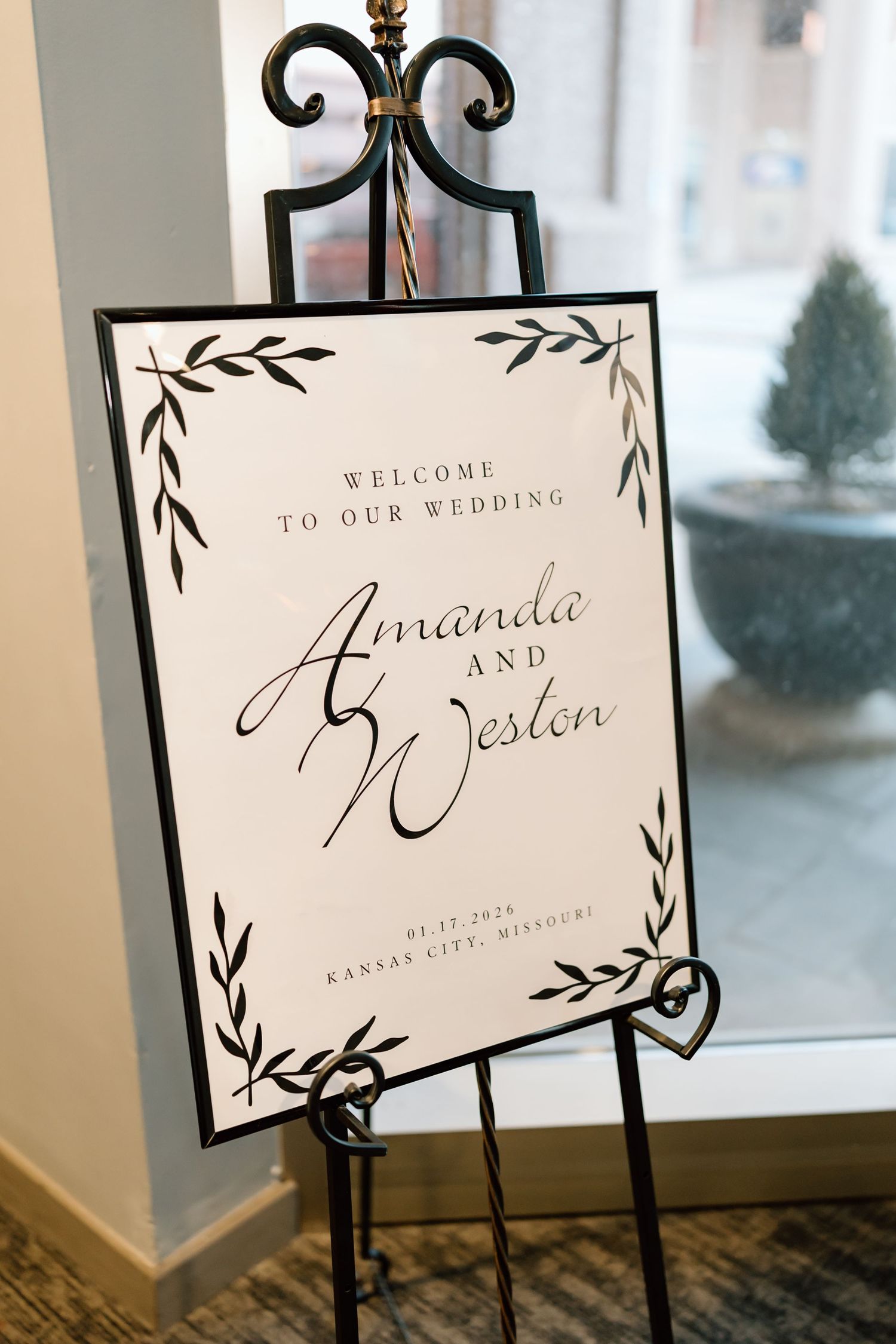 Elegant wedding welcome signs with black frames and calligraphy text displayed on wooden surface.