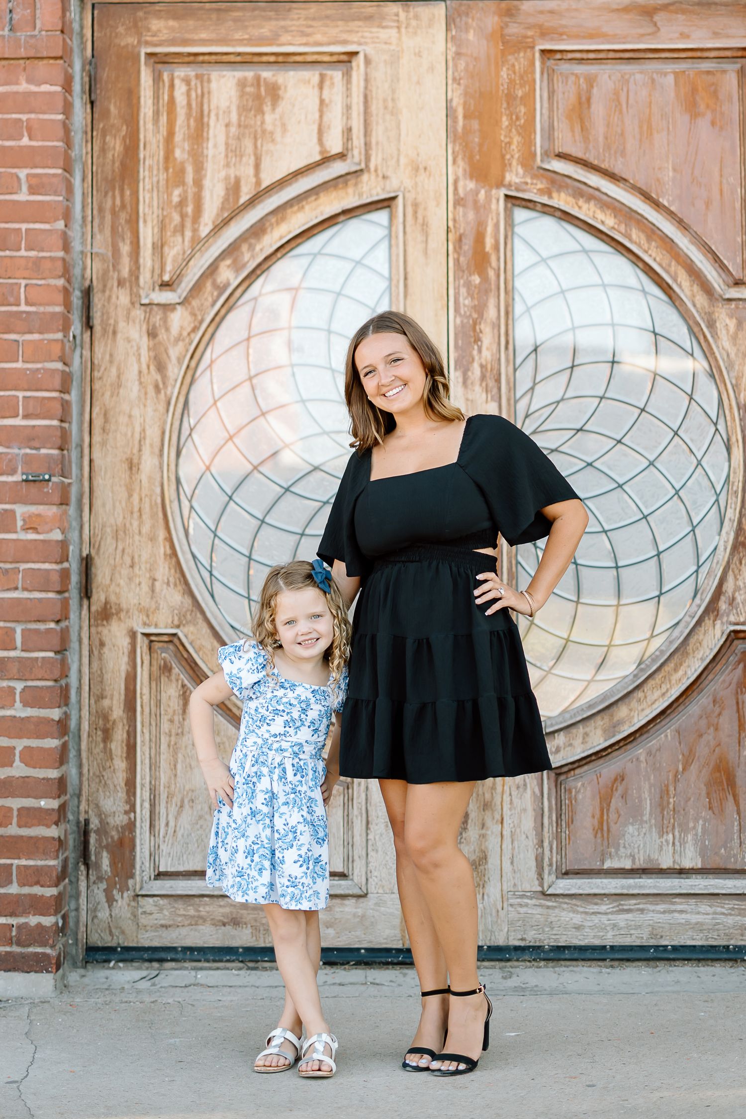A series of four photos showing a parent and child posing together against a rustic wooden door with circular windows.