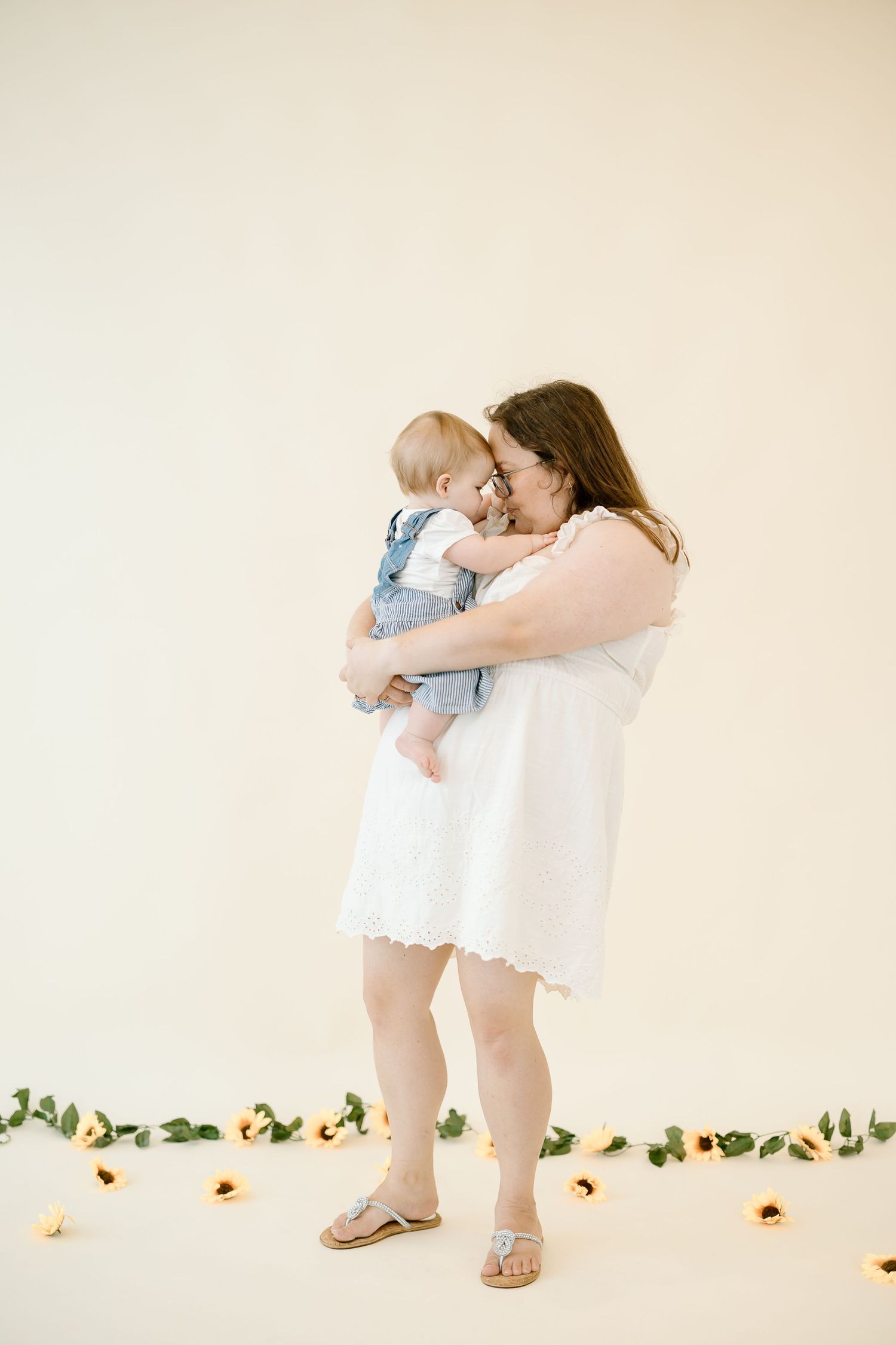 A series of photos showing a person in a white dress bending down near yellow flowers arranged on the floor.