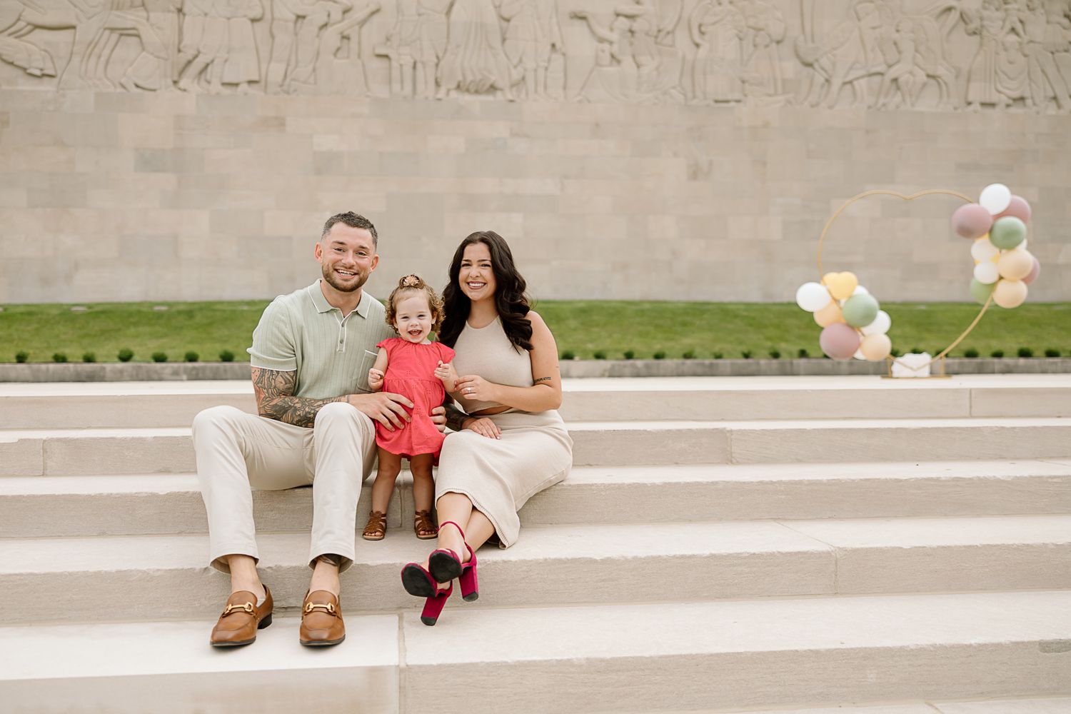 A joyful family moment captured on concrete steps with an urban landscape in the background.