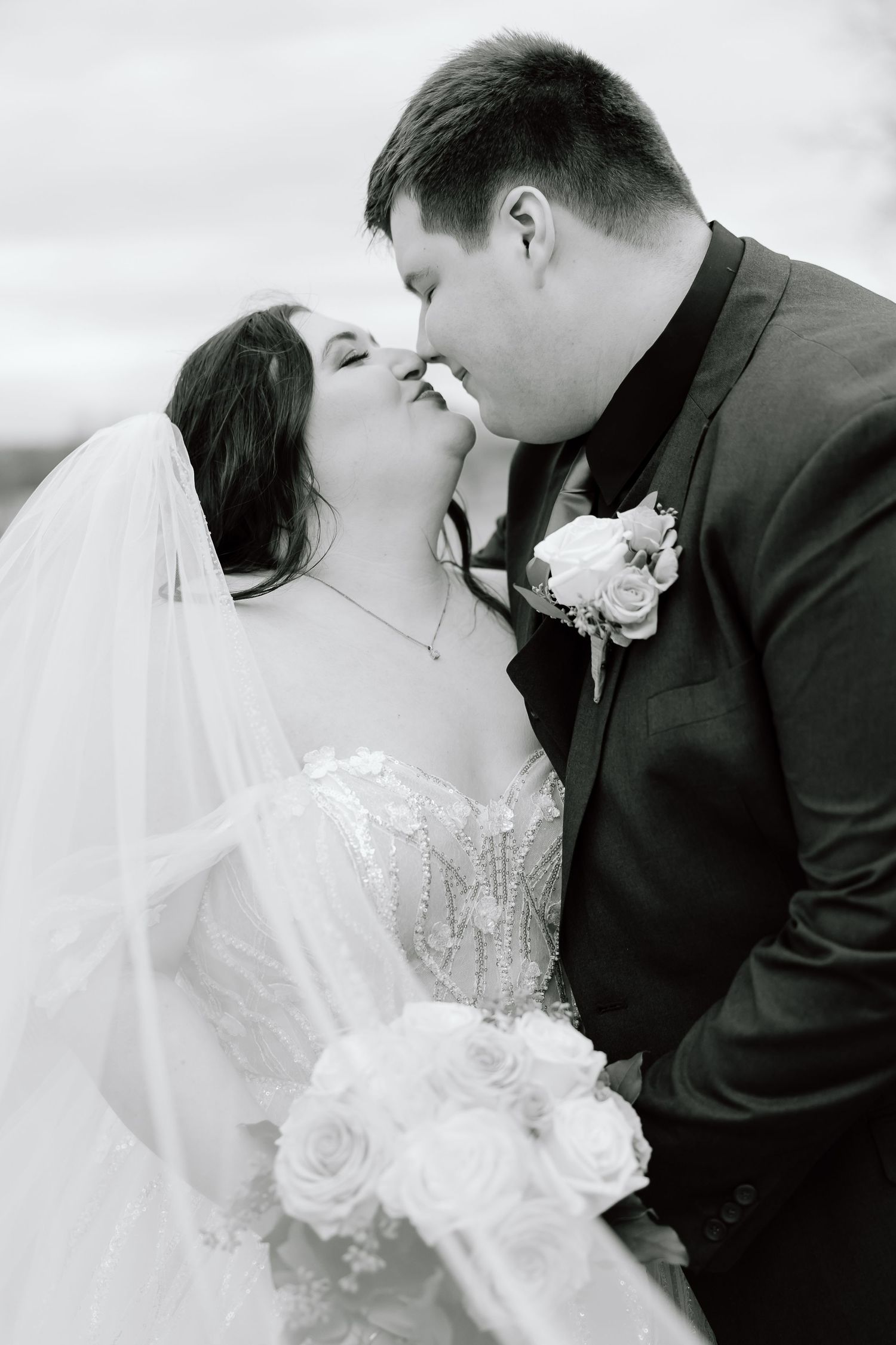 A romantic black and white photo sequence shows a bride and groom sharing their first kiss as newlyweds.