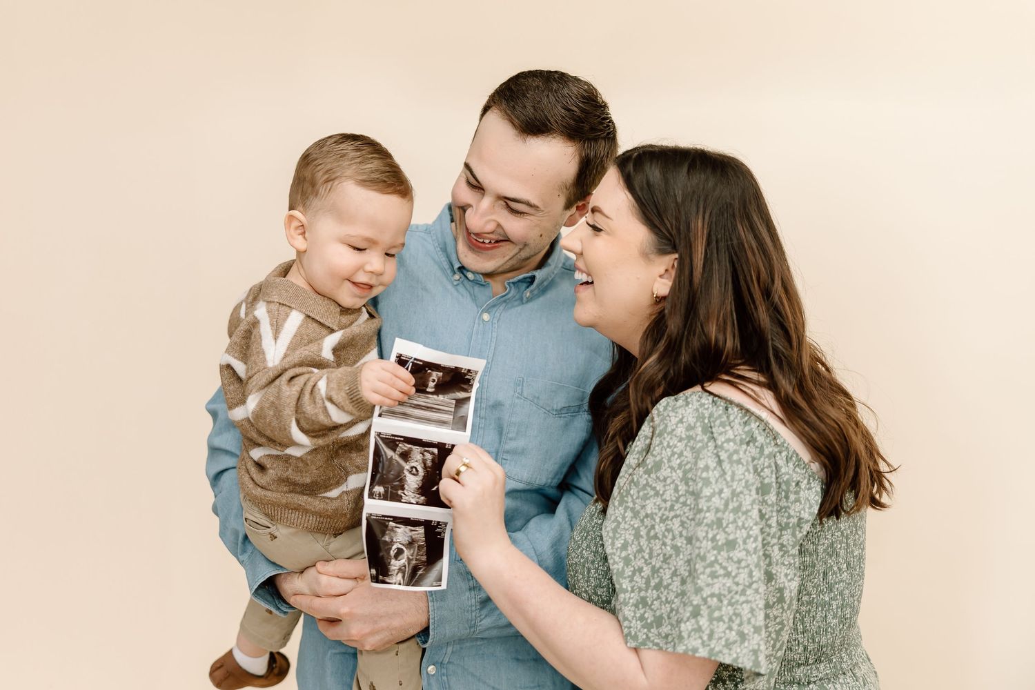 A happy family shares joyful moments together while looking at ultrasound photos in a series of candid shots.