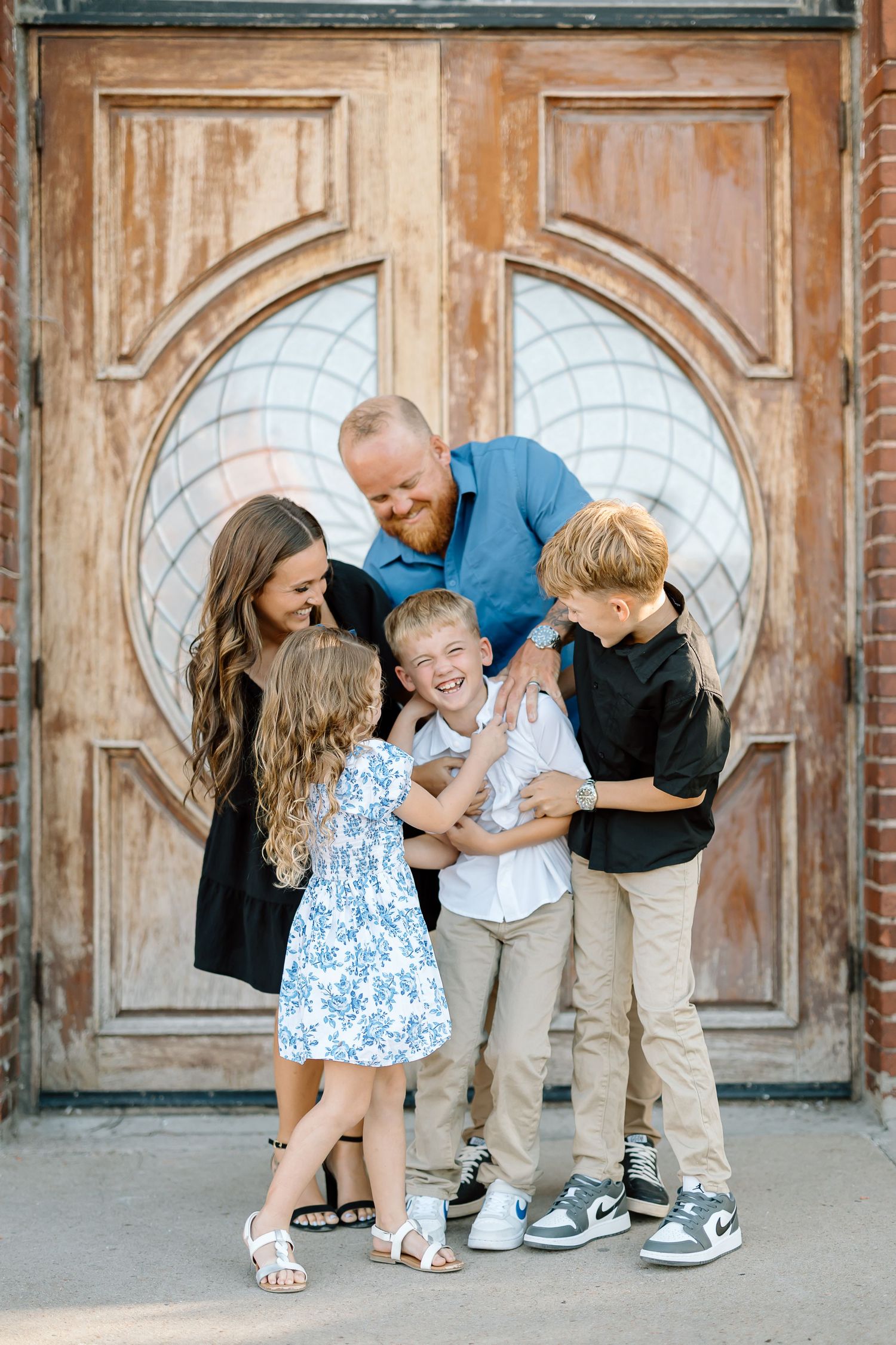 A joyful family moment captured in a sequence of playful interactions against a rustic wooden door backdrop.