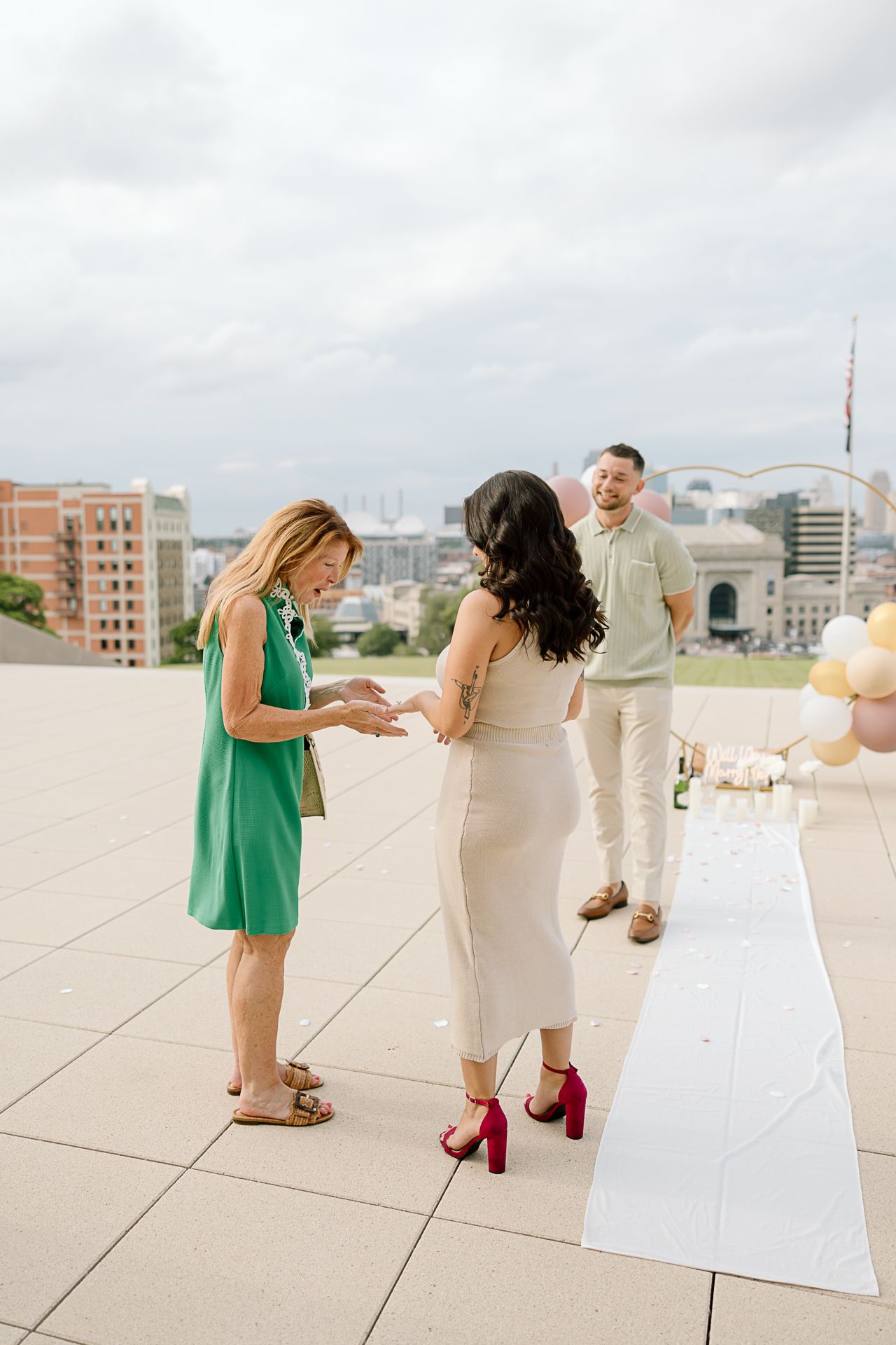 A series of five photos showing people in green and white outfits interacting on a rooftop terrace with city buildings in background.