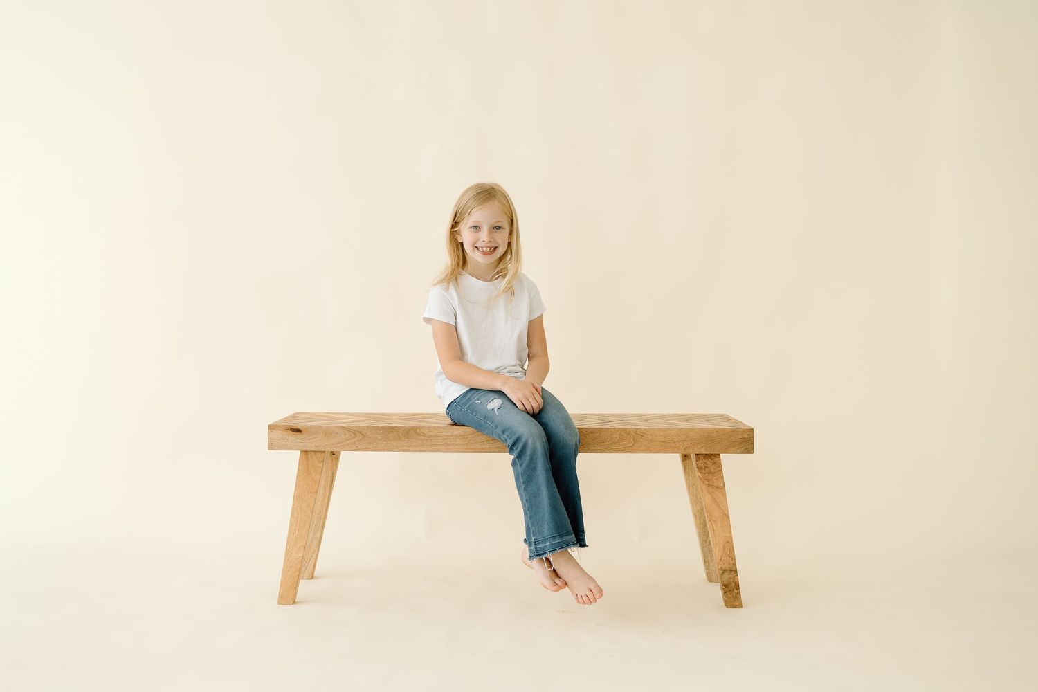 A person sits on a wooden bench against a white background in various poses showing different angles.