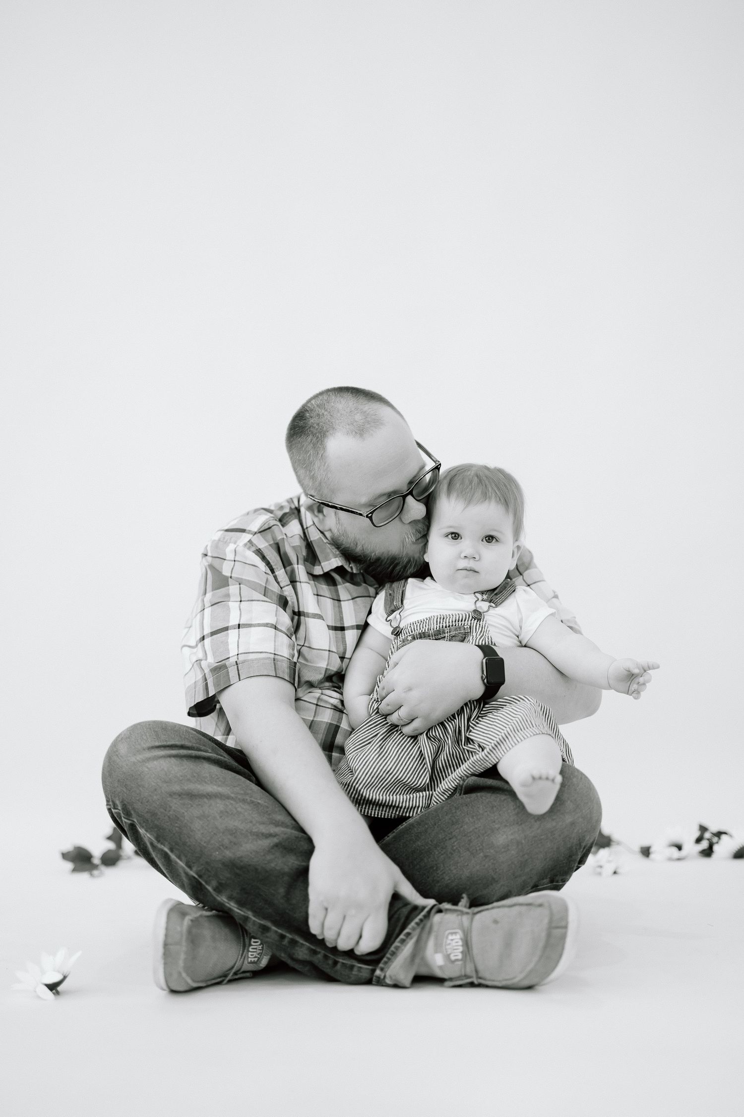 A heartwarming black and white photo series showing tender moments between an adult and baby sitting together.