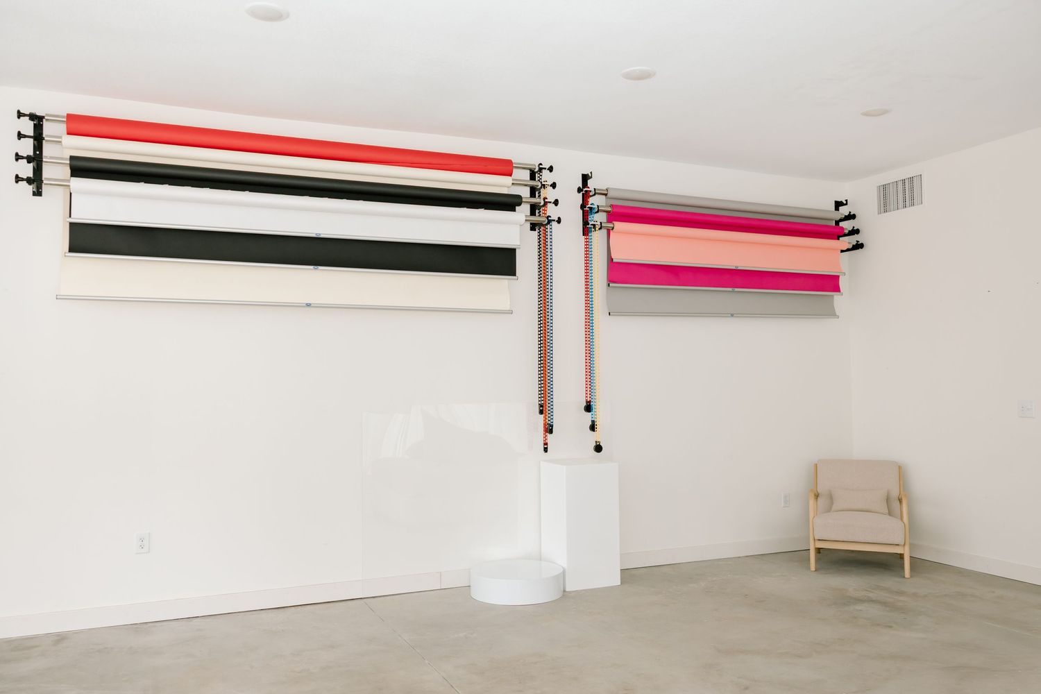 Minimalist art gallery space with horizontal striped artworks mounted on white walls.