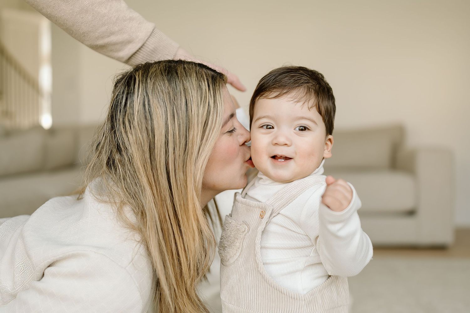 A series of tender moments between parent and baby in a bright, minimalist setting with white decor and natural lighting.
