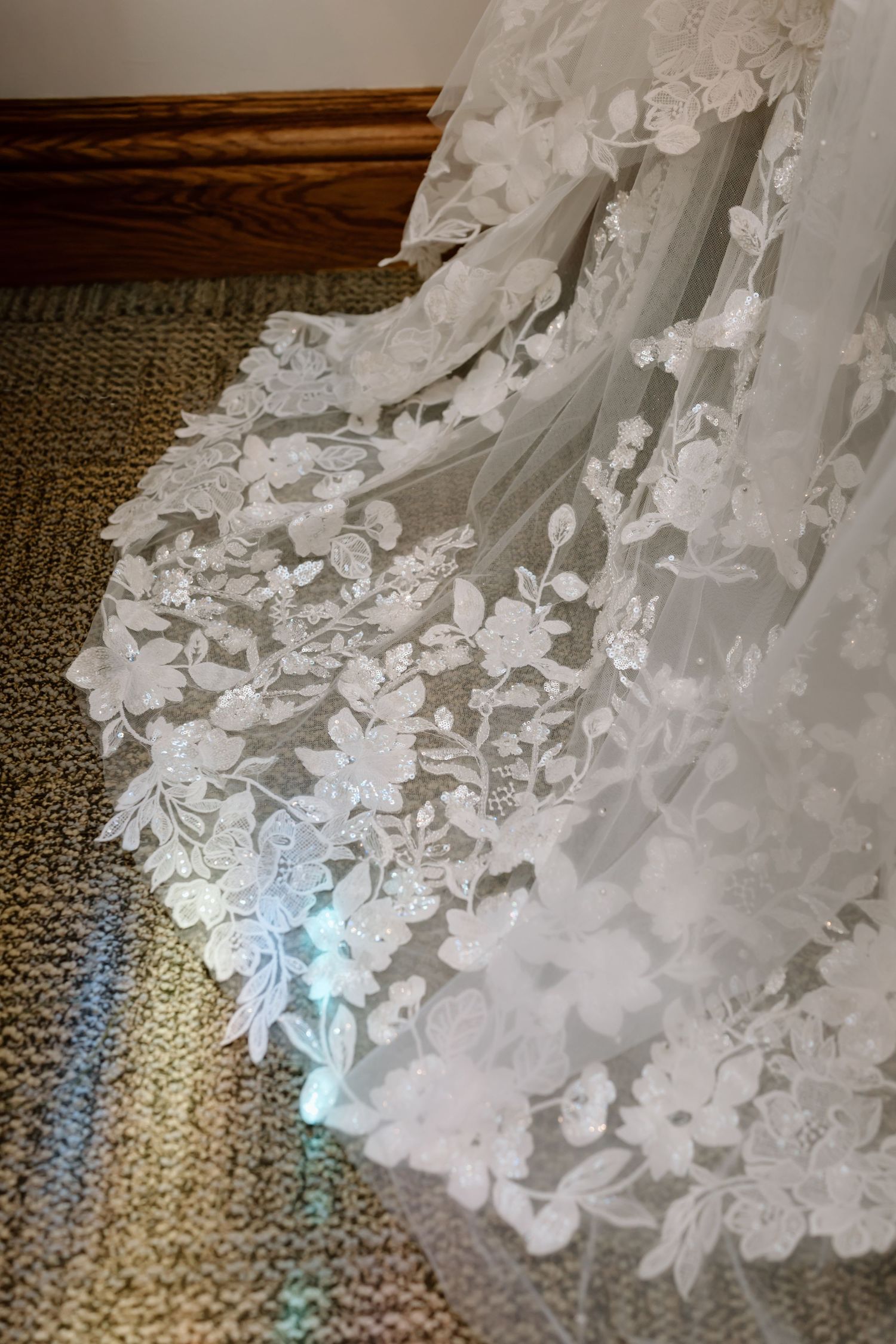 Delicate white floral lace details and embellishments on a textured fabric background create an elegant bridal design pattern.