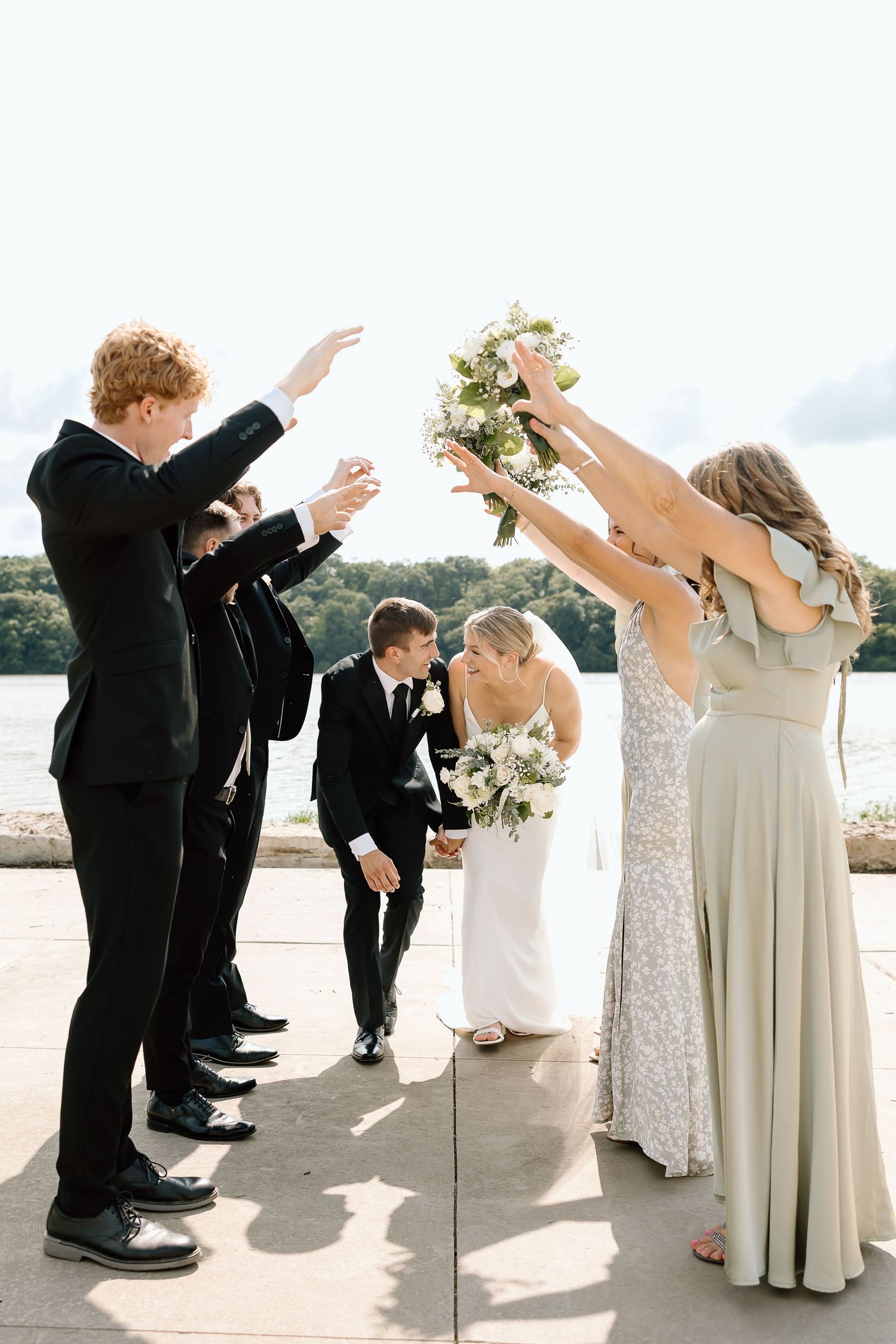 Wedding party strikes fun poses in a sequence of photos showing joyful jumping movements on a bright outdoor terrace.