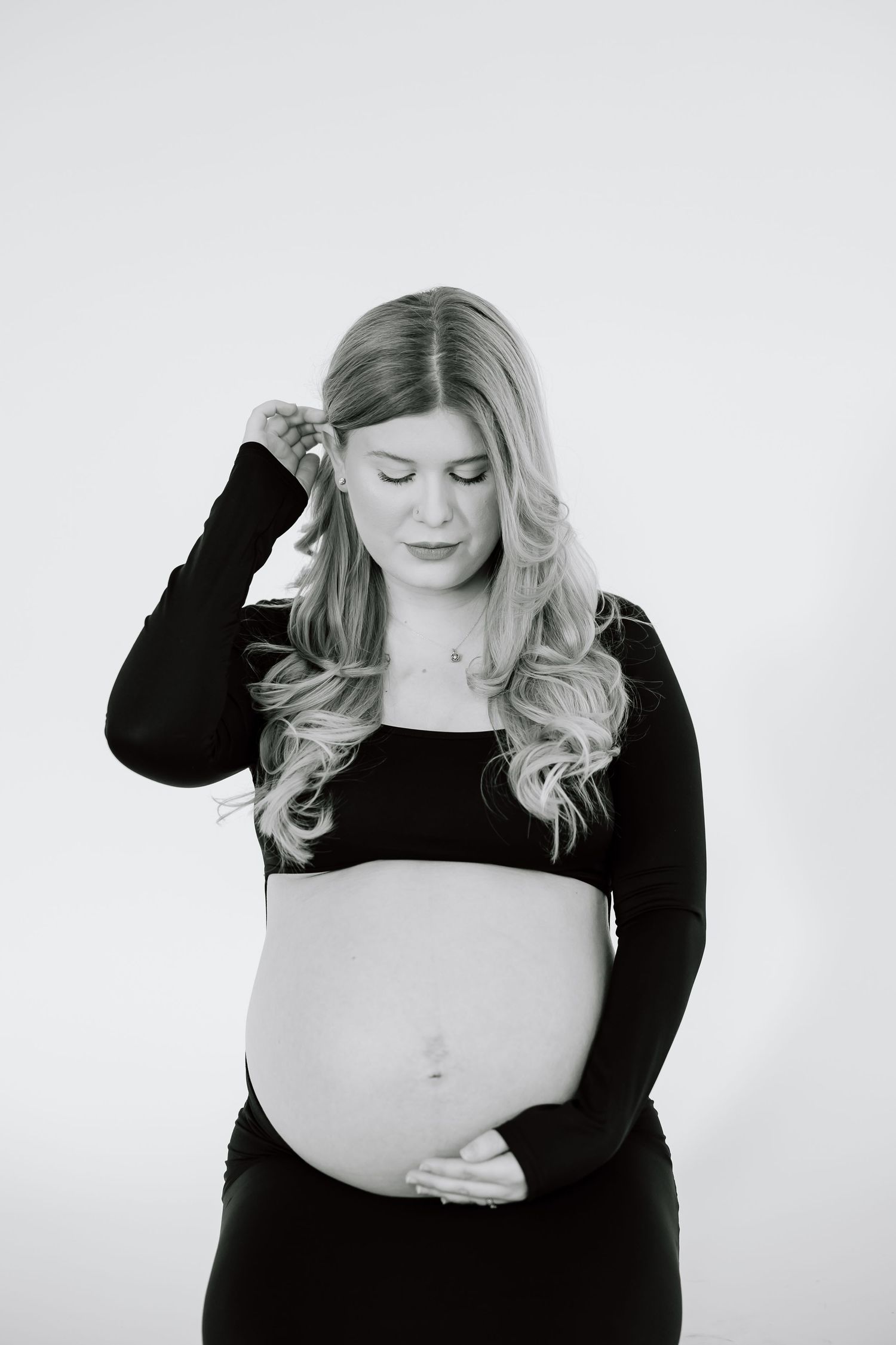 Black and white photo series showing woman in dark top posing expressively against white background.