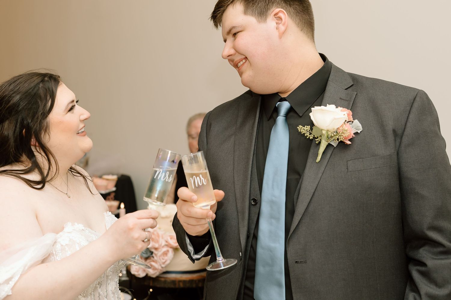 A couple shares a celebratory toast with wine glasses at a formal event.