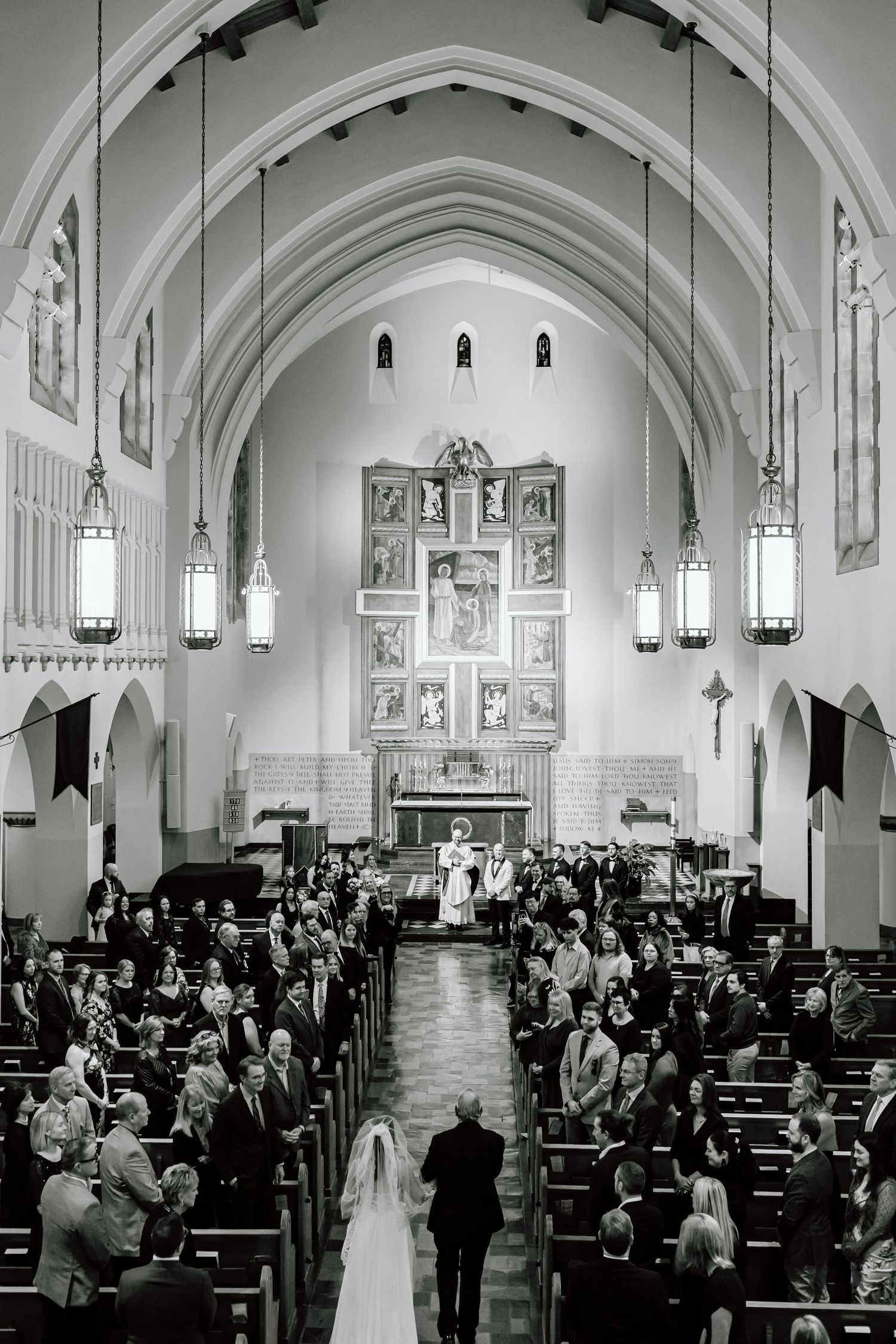 A black and white photo series showing a wedding ceremony in a grand cathedral with arched ceilings and stained glass windows.