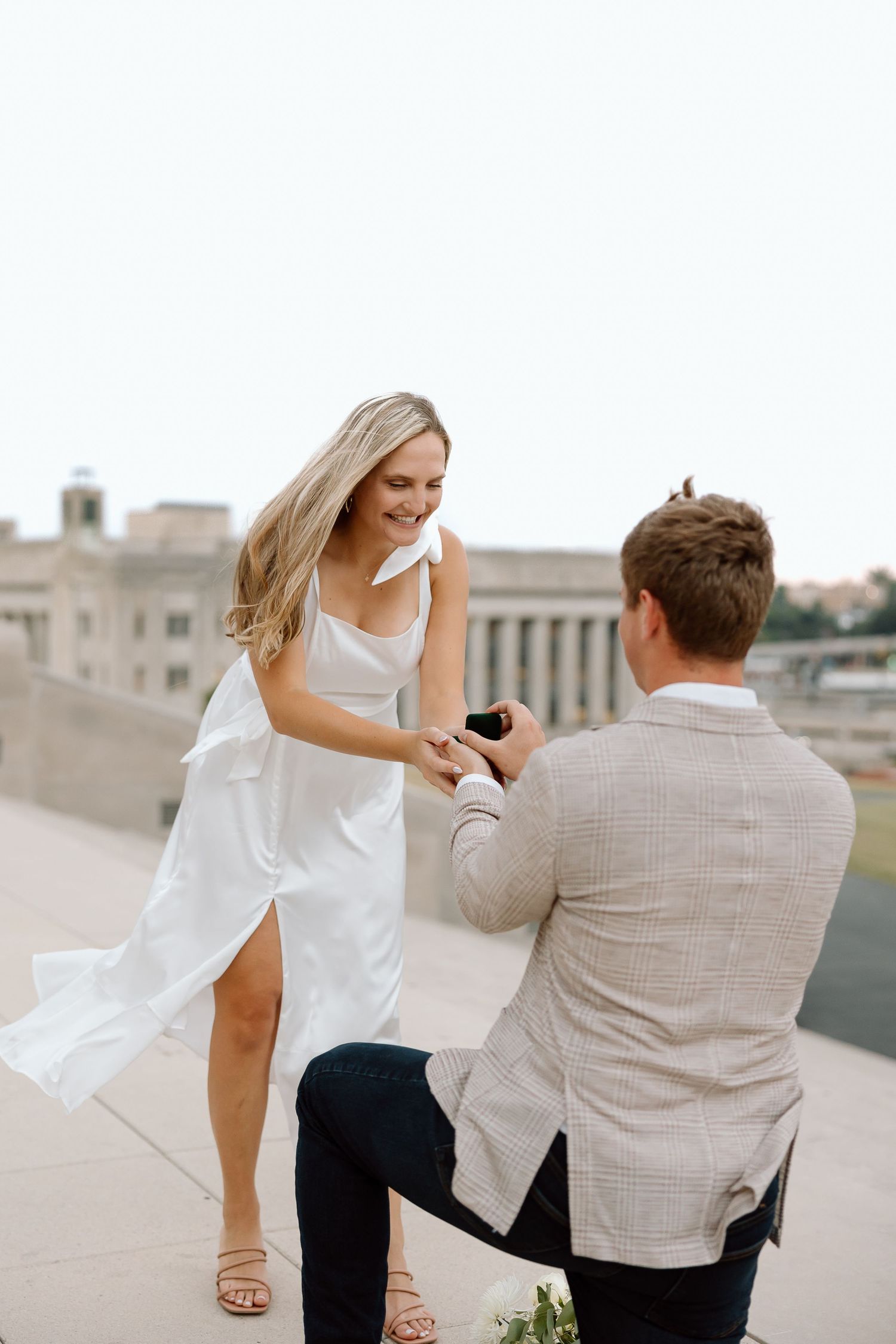 A couple shares a romantic moment on a rooftop during a proposal sequence in four candid shots.