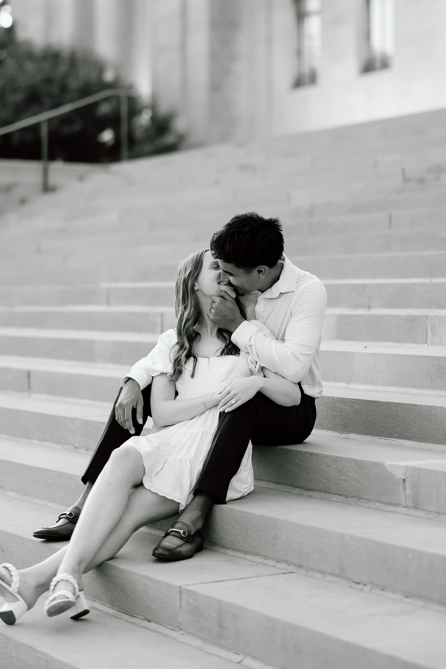 A romantic black and white photo series showing a couple embracing on concrete steps outdoors.
