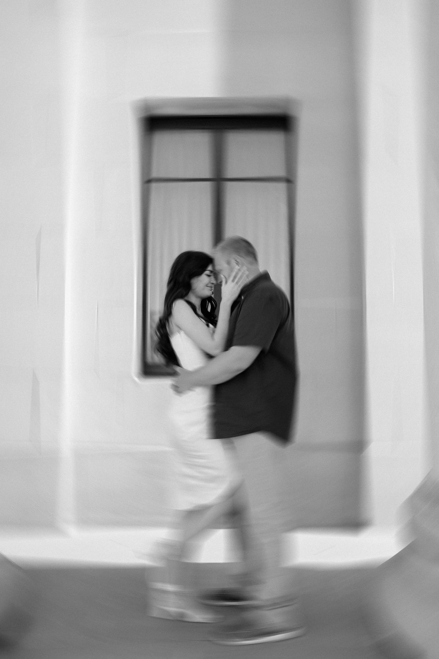 A series of black and white photos showing a figure in motion through a minimalist hallway with windows.