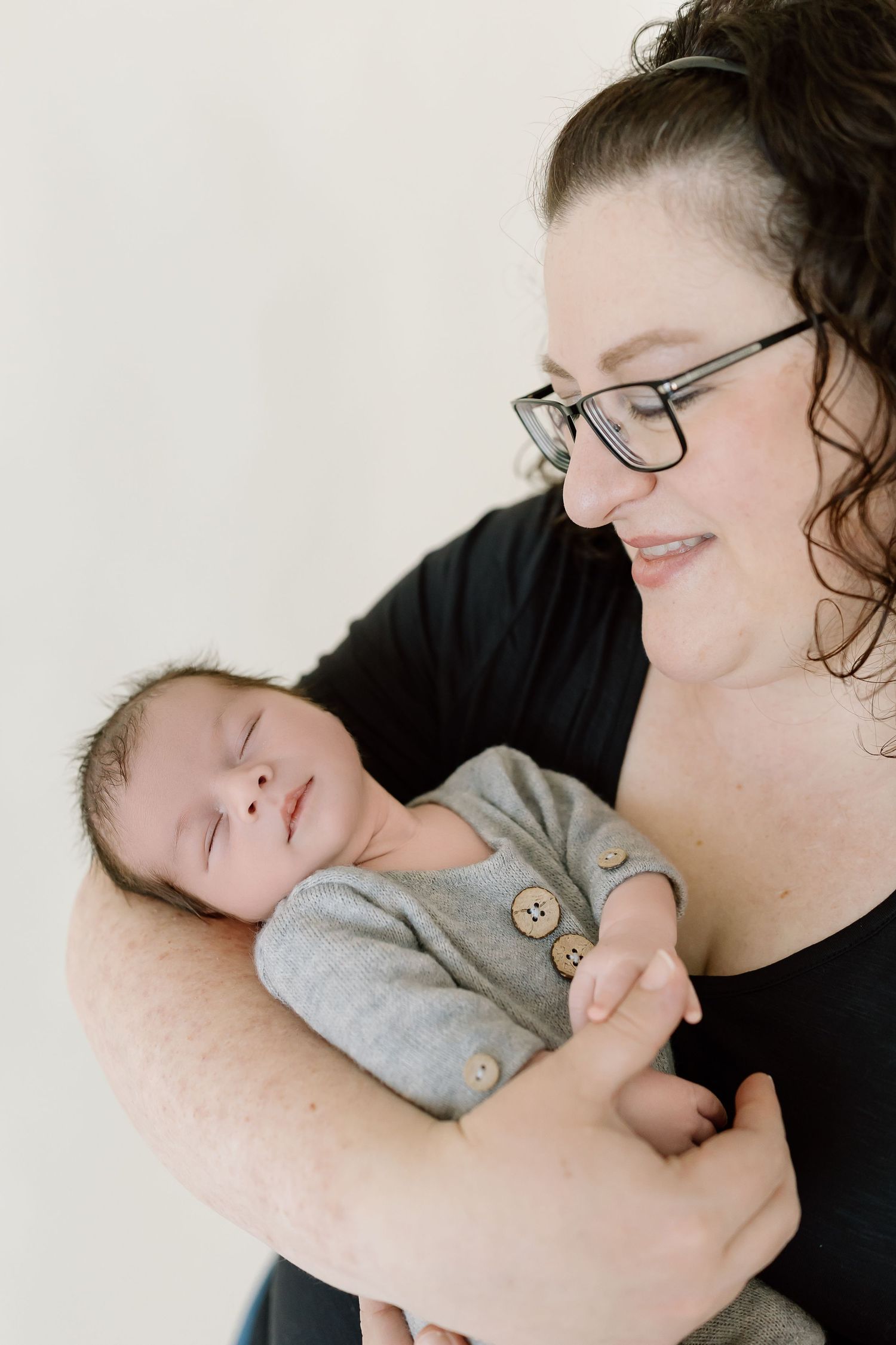A tender moment between parent and newborn baby as they cuddle together in a series of intimate portraits.