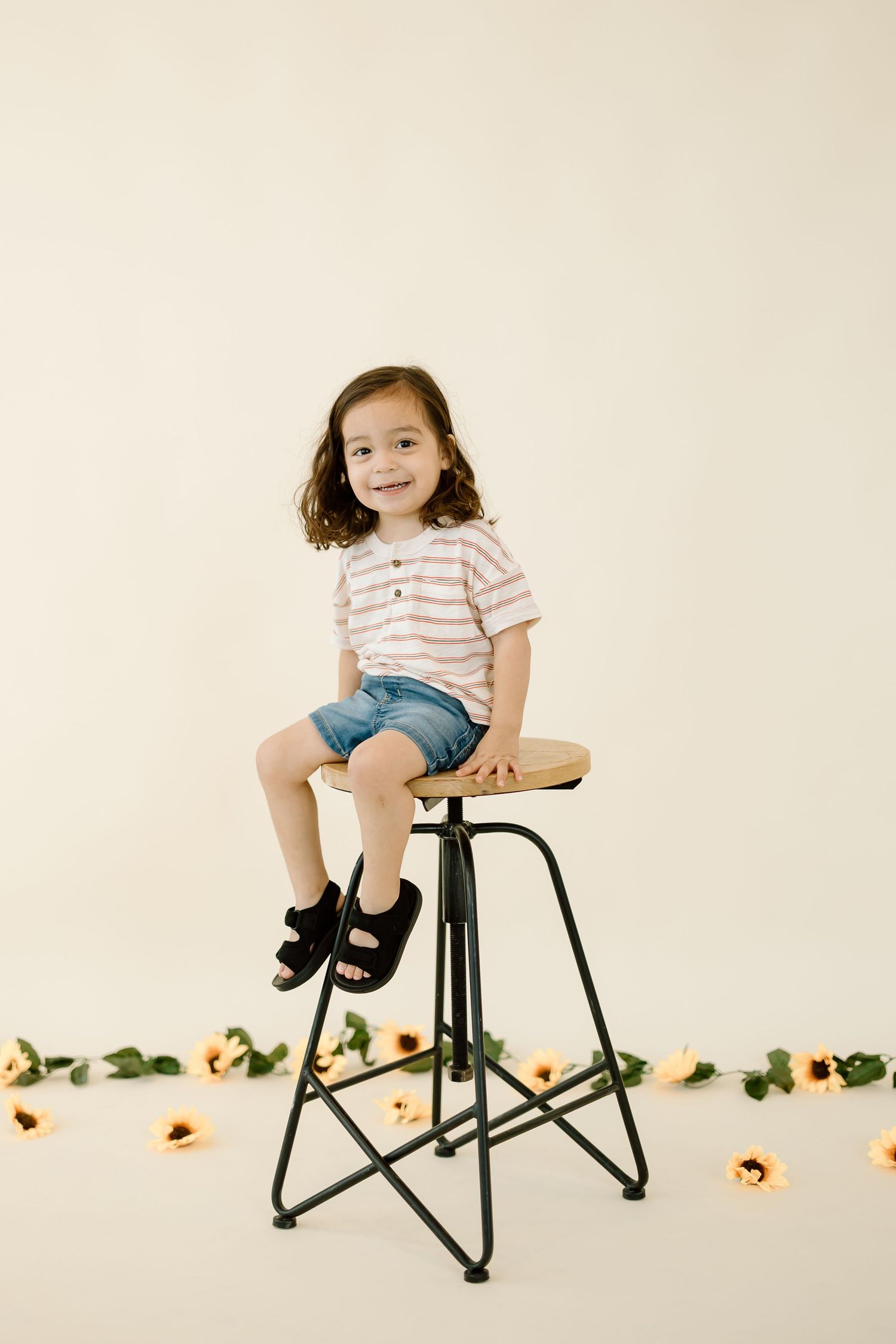 A sequence of photos showing a small child sitting on a black stool against a light background with sunflowers.