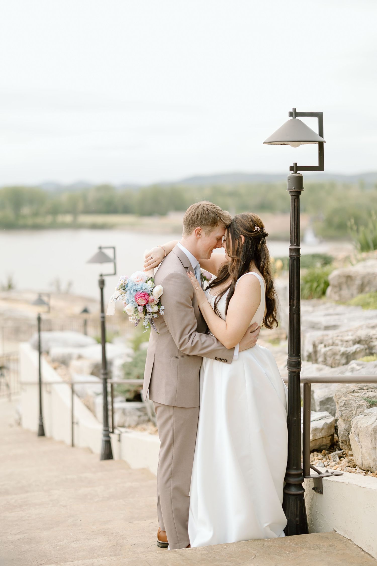 Intimate wedding portrait by vintage lamp post with scenic overlook.